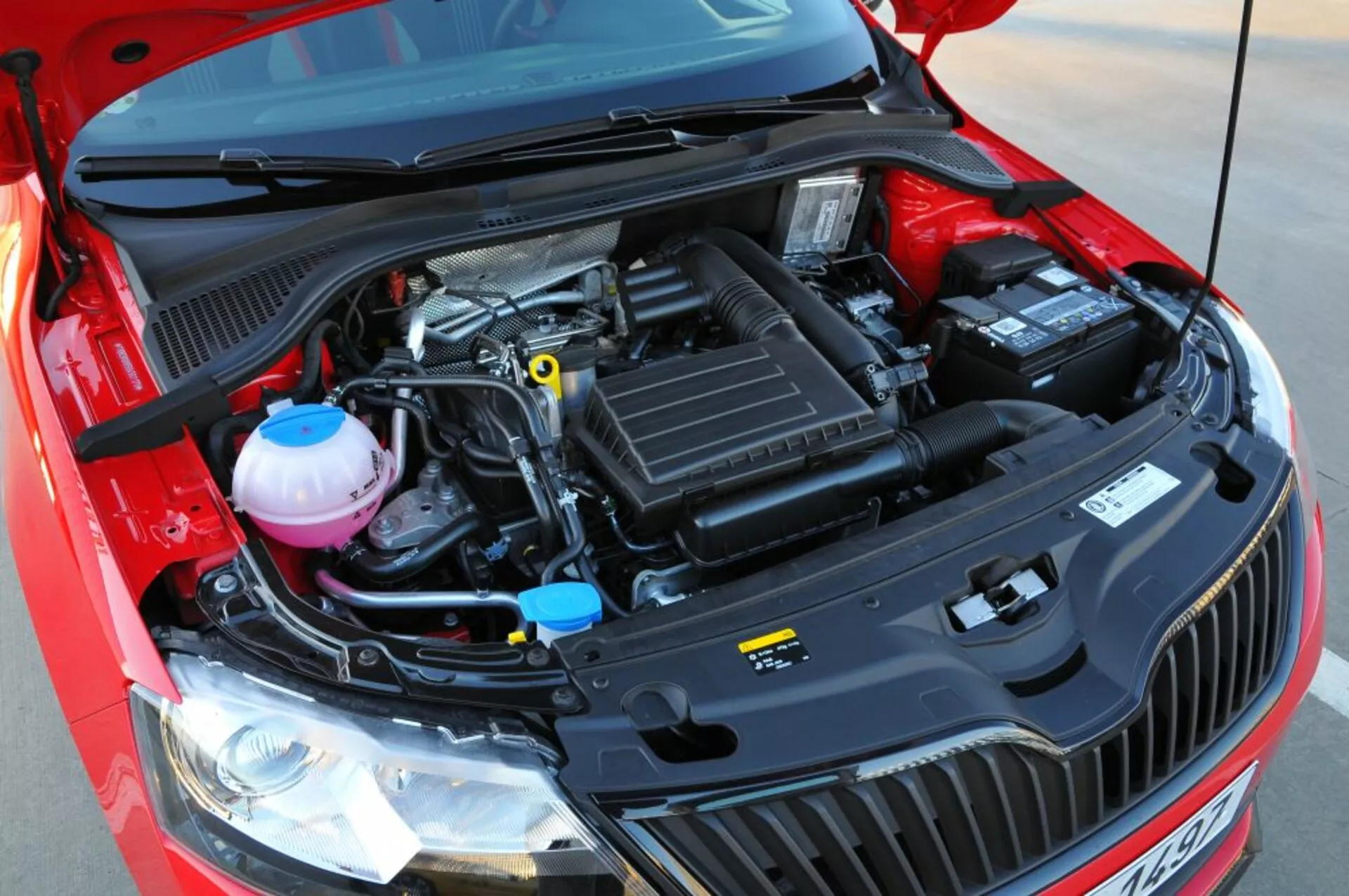 Vue rapprochée du compartiment moteur ouvert d'une Opel Astra 2005 (Astra TwinTop), mettant en avant les composants mécaniques tels que le boîte à air, couvercle du moteur, réservoirs de liquide de refroidissement et de frein, et batterie, sous un angle frontal surélevé