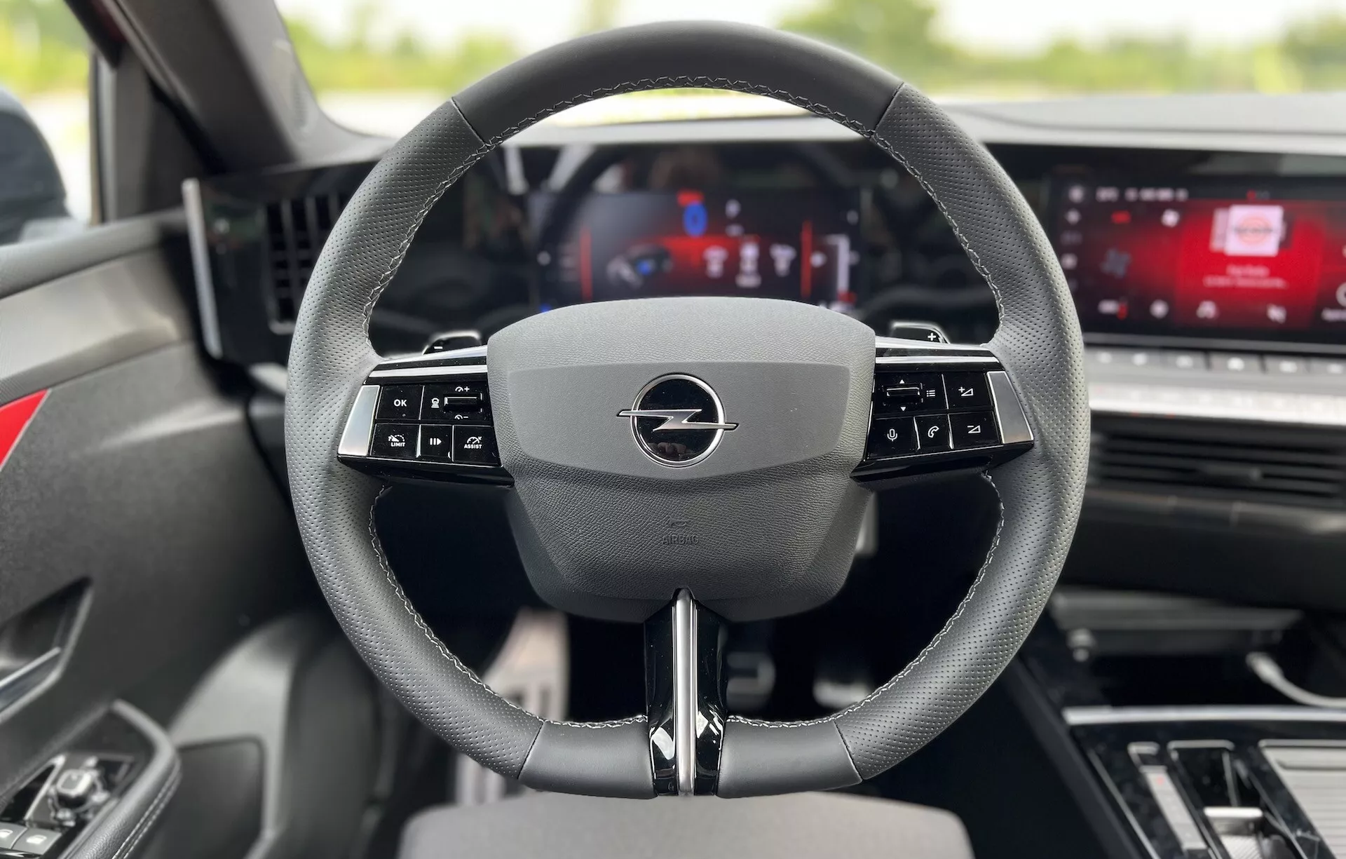 Vue intérieure de l'Opel Astra 2022 depuis le siège du conducteur, centrée sur le volant multifonction moderne et le tableau de bord numérique