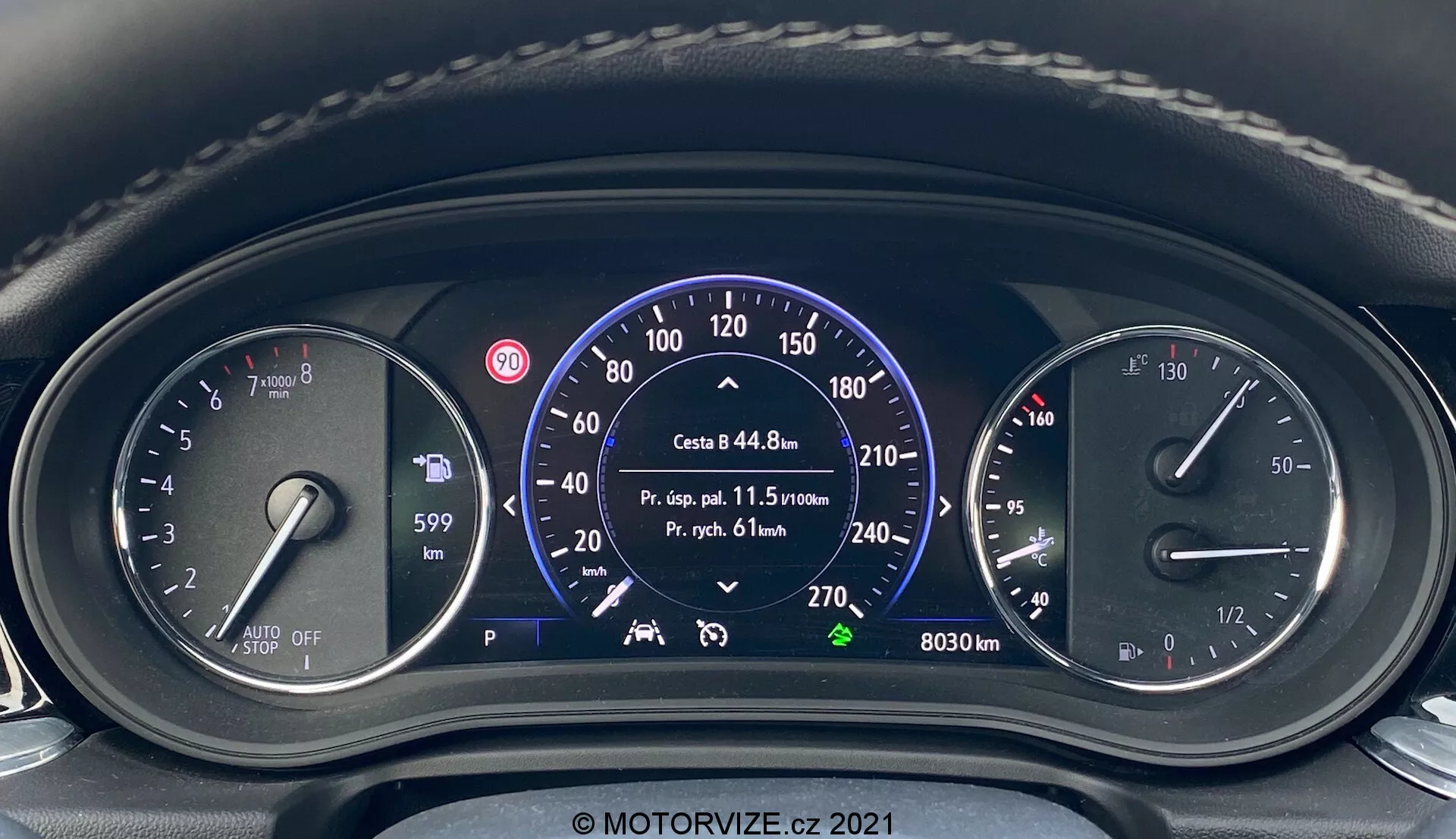Vue rapprochée du tableau de bord depuis la perspective du conducteur dans une Opel Insignia 2020 Insignia-GSi Grand Sport. Le tableau affiche un mélange de composants analogiques et numériques, y compris le niveau de carburant, les informations du système stop-start automatique, le grand compteur de vitesse avec des marquages en km/h et mph, les données de voyage, les indicateurs d'assistance de voie, le compte-tours moteur avec ligne rouge à 6500 RPM et plusieurs voyants d'avertissement. L'indicateur de position de vitesse montre 'P' pour parc. Filigrane informatif 'MOTORVIZE.cz 2021'.
