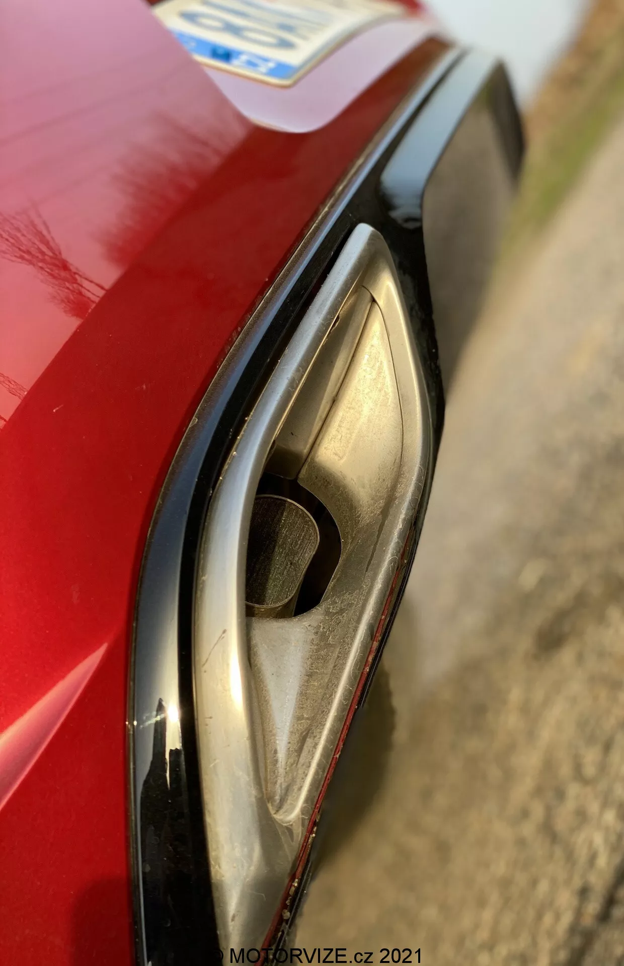 Gros plan sur le phare avant gauche de l’Opel Insignia 2020 GSi Grand Sport, mettant en valeur sa technologie moderne LED ou HID. La perspective légèrement en hauteur souligne la courbe distincte du phare, le boîtier transparent, les clignotants intégrés ou les feux de jour et l’aile avant rouge. La faible profondeur de champ met en évidence le phare avec un arrière-plan flou.