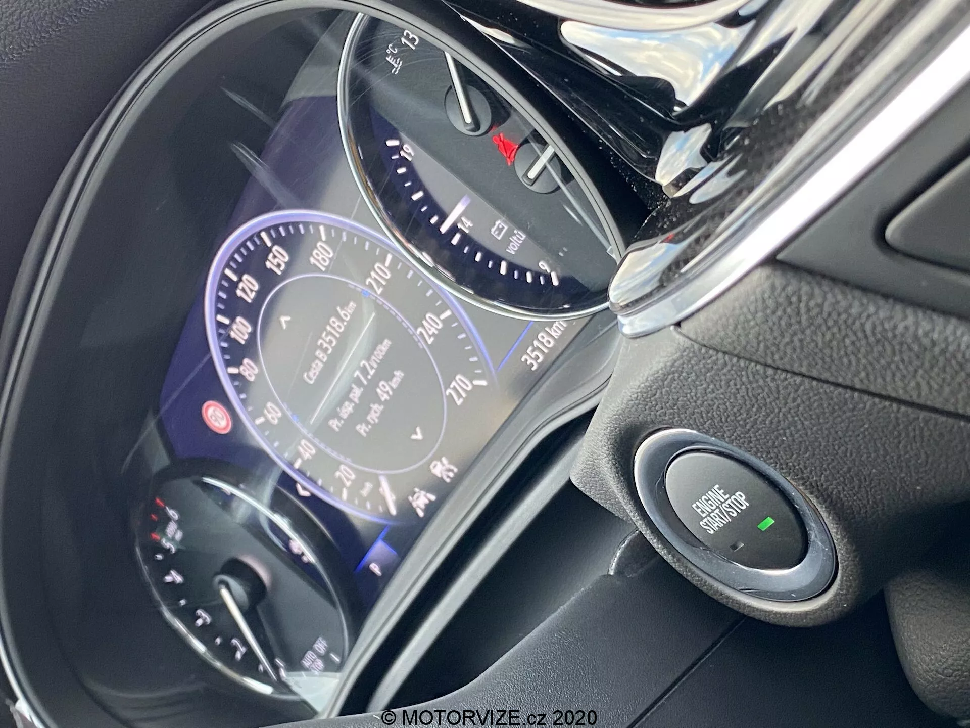 Vue rapprochée du tableau de bord et de la colonne de direction de l'Opel Insignia 2020 Sports Tourer du point de vue du conducteur. L'image affiche un tableau de bord numérique avec un compteur de vitesse de style analogique marqué jusqu'à 260 km/h, indicateur de carburant avec une autonomie de 70 km, indicateur de vitesse, odomètre montrant 75158 km, bouton de démarrage-arrêt du moteur et divers voyants d'avertissement de sécurité pour les fonctions technologiques avancées.