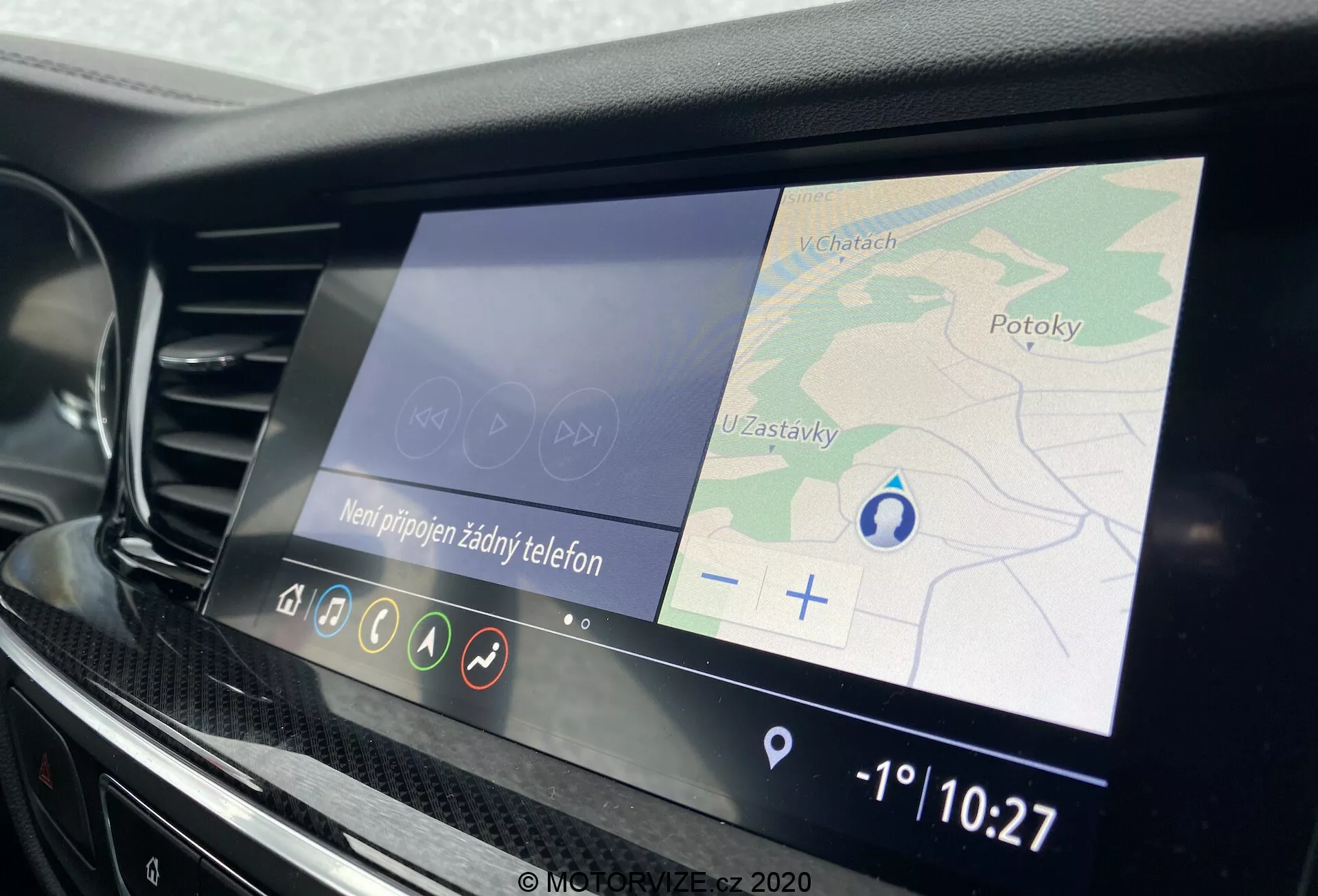 Intérieur de la Opel Insignia Sports Tourer 2020 mettant en avant un système d'infodivertissement moderne avec un écran tactile couleur de 8 à 10 pouces affichant la navigation GPS, les noms de rue et une flèche bleue indiquant la direction du véhicule. La console centrale comprend des commandes tactiles et des accents noirs brillants et chromés, indiquant un aspect premium.