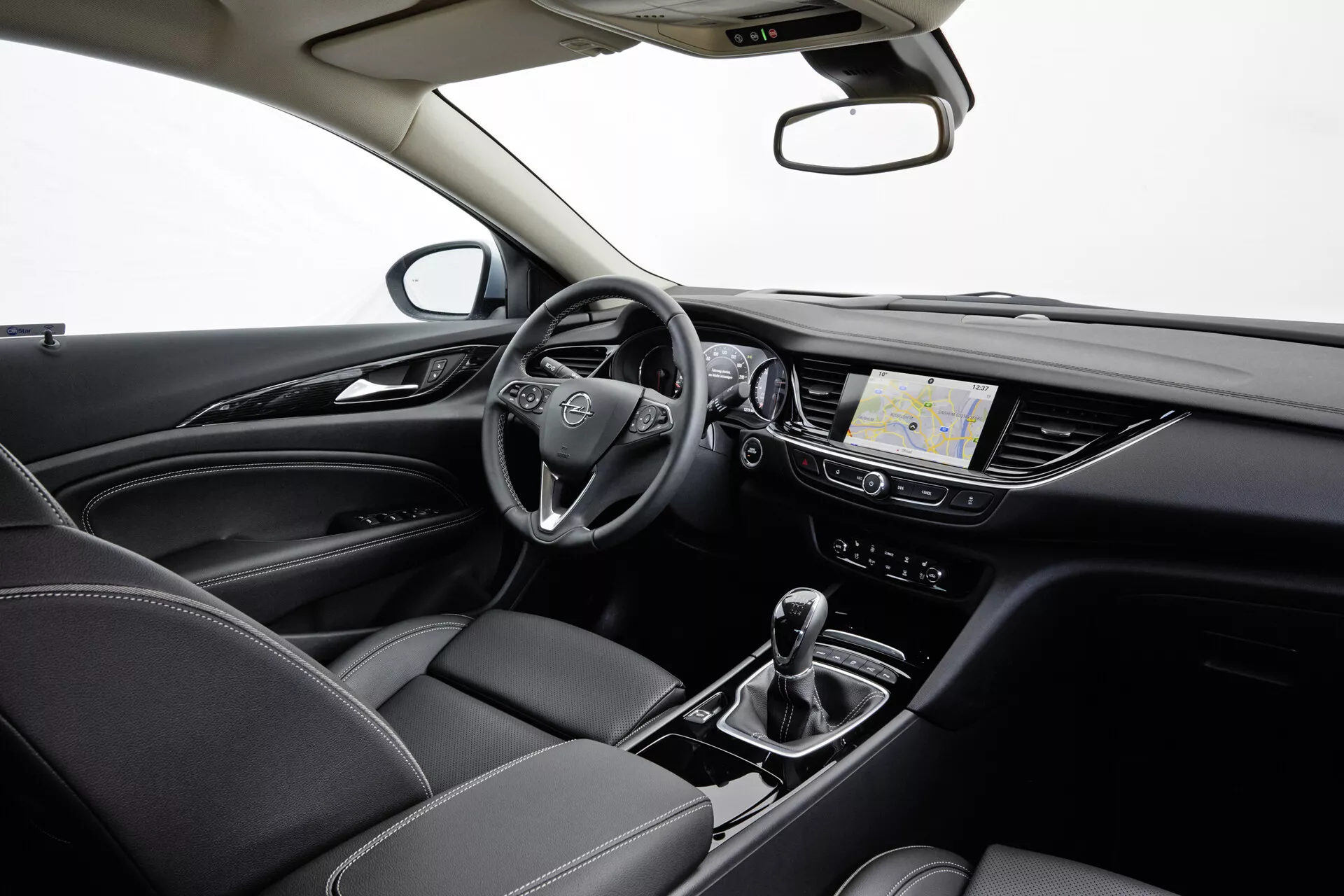 Intérieur de l'Opel Insignia 2013 présentant un volant multifonction, tableau de bord numérique, système d'infodivertissement tactile avec navigation, transmission automatique avec sélecteur de mode de conduite, contrôle climatique et sièges en cuir avec coutures détaillées, le tout sous un éclairage professionnel de studio.