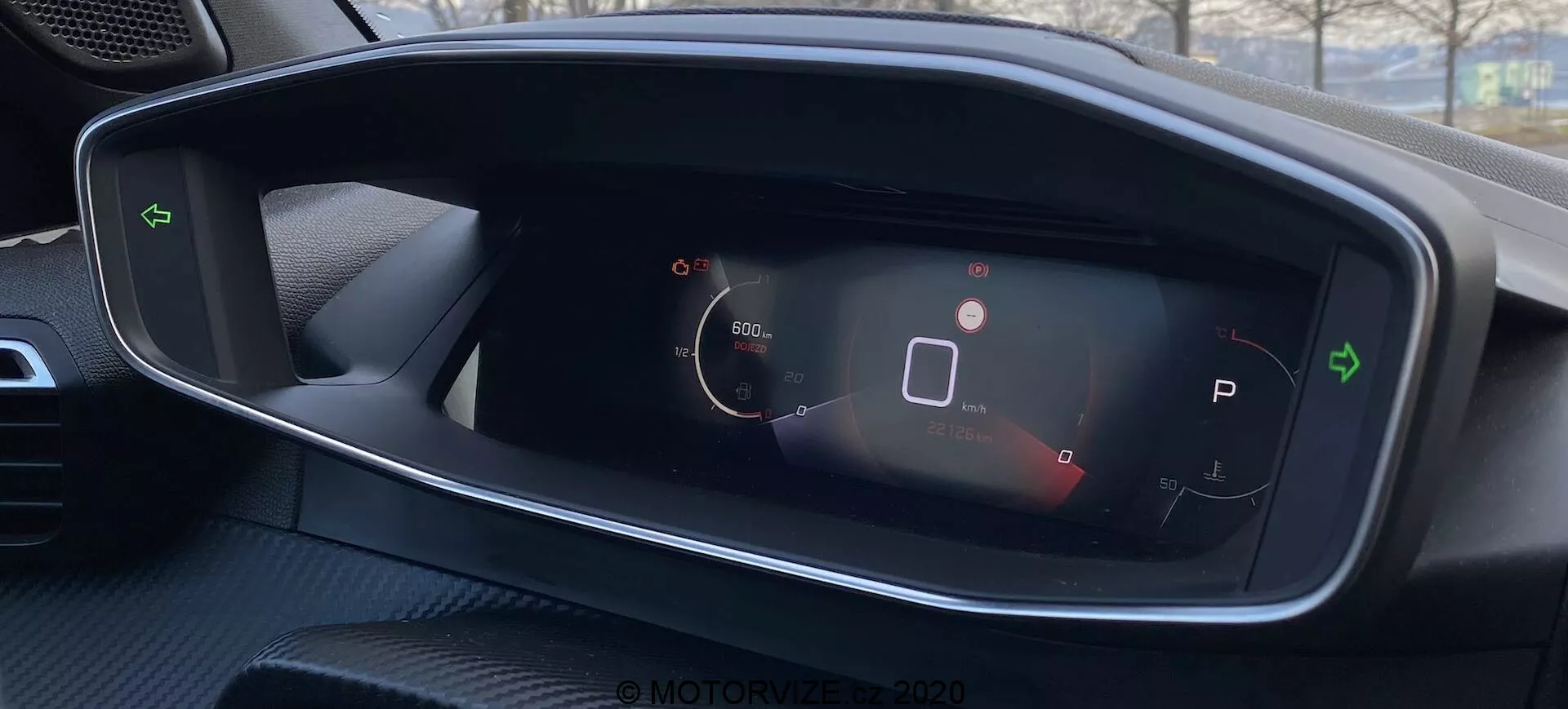 Vue rapprochée du tableau de bord numérique de la Peugeot 2008 2020, avec indicateur de vitesse, icône d'état du véhicule, sélection de vitesse en mode parking, symbole de batterie et autres indicateurs d'état. Design épuré et à fort contraste depuis la perspective du conducteur.