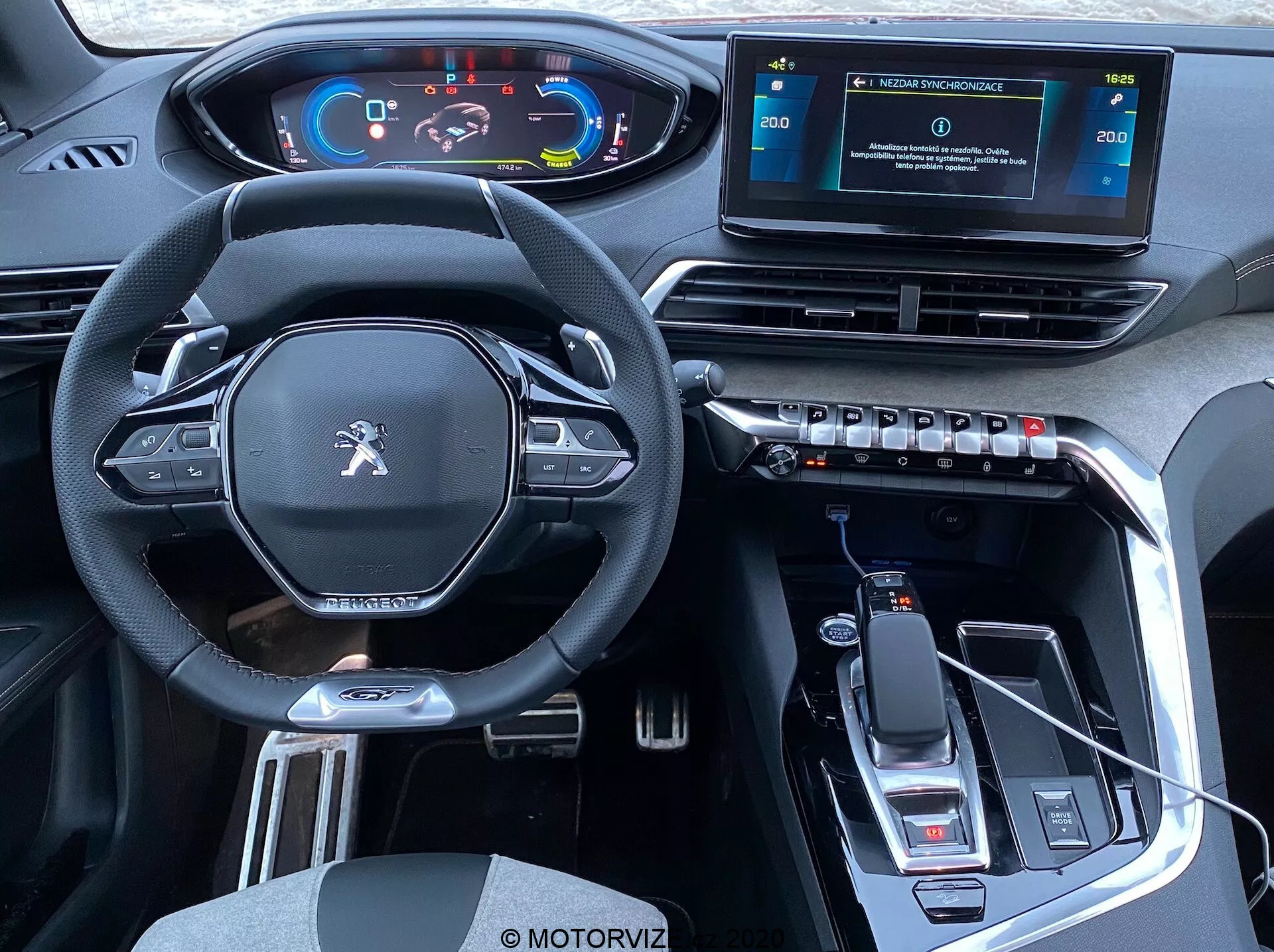 Vue intérieure d'une Peugeot 3008 2021 depuis les sièges arrière montrant l'habitacle avant : volant multifonction moderne au design plat avec boutons de commande, tableau de bord numérique, console centrale surélevée avec sélecteur de vitesse et frein de stationnement électronique, système d'infodivertissement avec écran tactile autonome, bouches d'aération rectangulaires avec commandes de climatisation, design intérieur élégant avec matériau imitant le cuir, accents métalliques, garniture noire brillante, connectivité USB, indications de transmission automatique, porte-gobelets et espace de rangement.