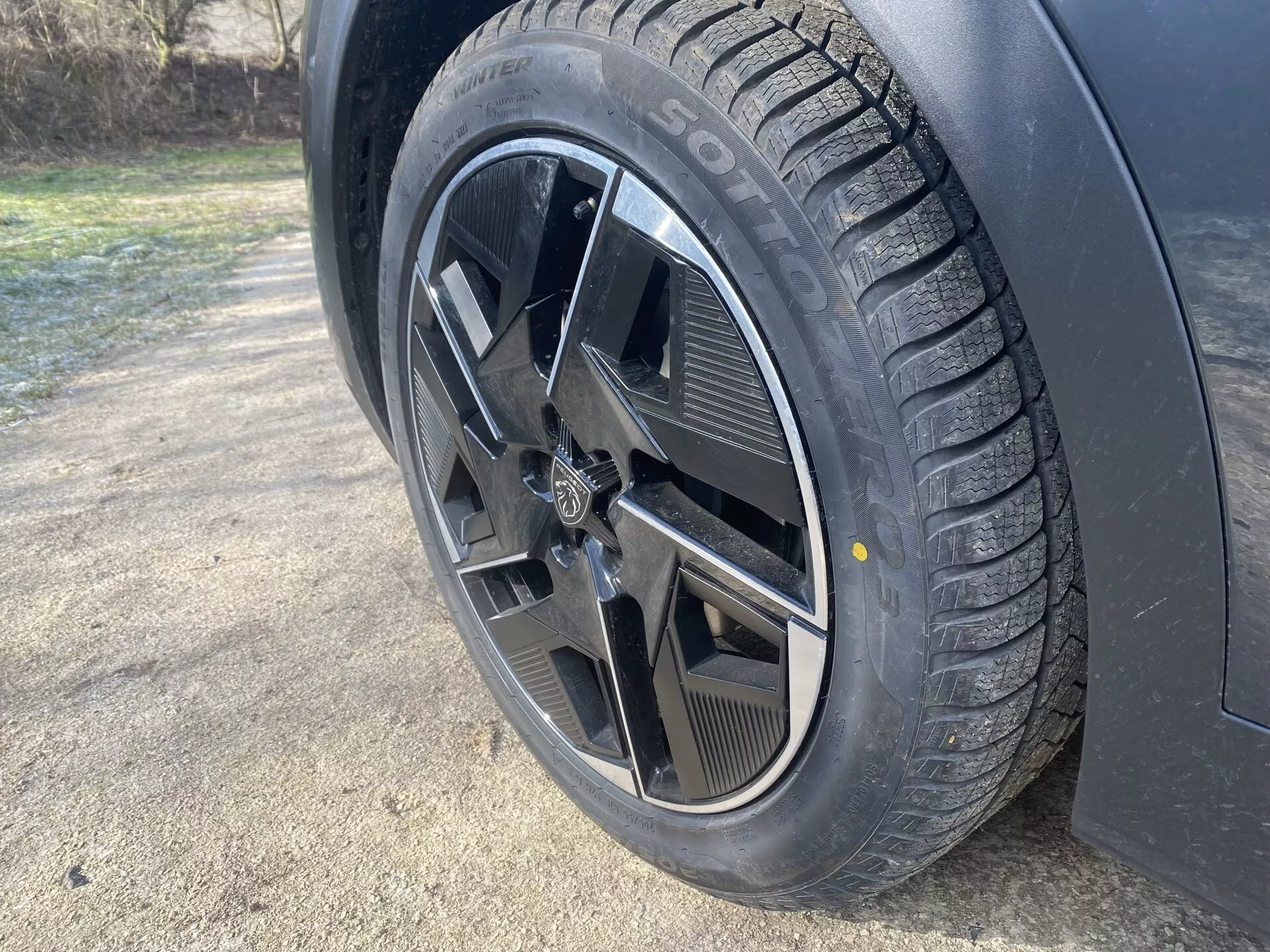 Gros plan sur la roue de la Peugeot 408 2023 montrant le pneu hiver SOTTOZERO et la jante à cinq branches doubles dans un cadre extérieur avec gelée