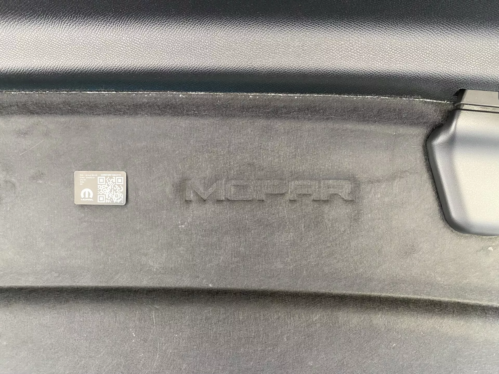 Vue rapprochée du revêtement de coffre de la Peugeot 408 2023 avec texture MOPAR, code-barres et code QR pour l'identification des pièces OEM