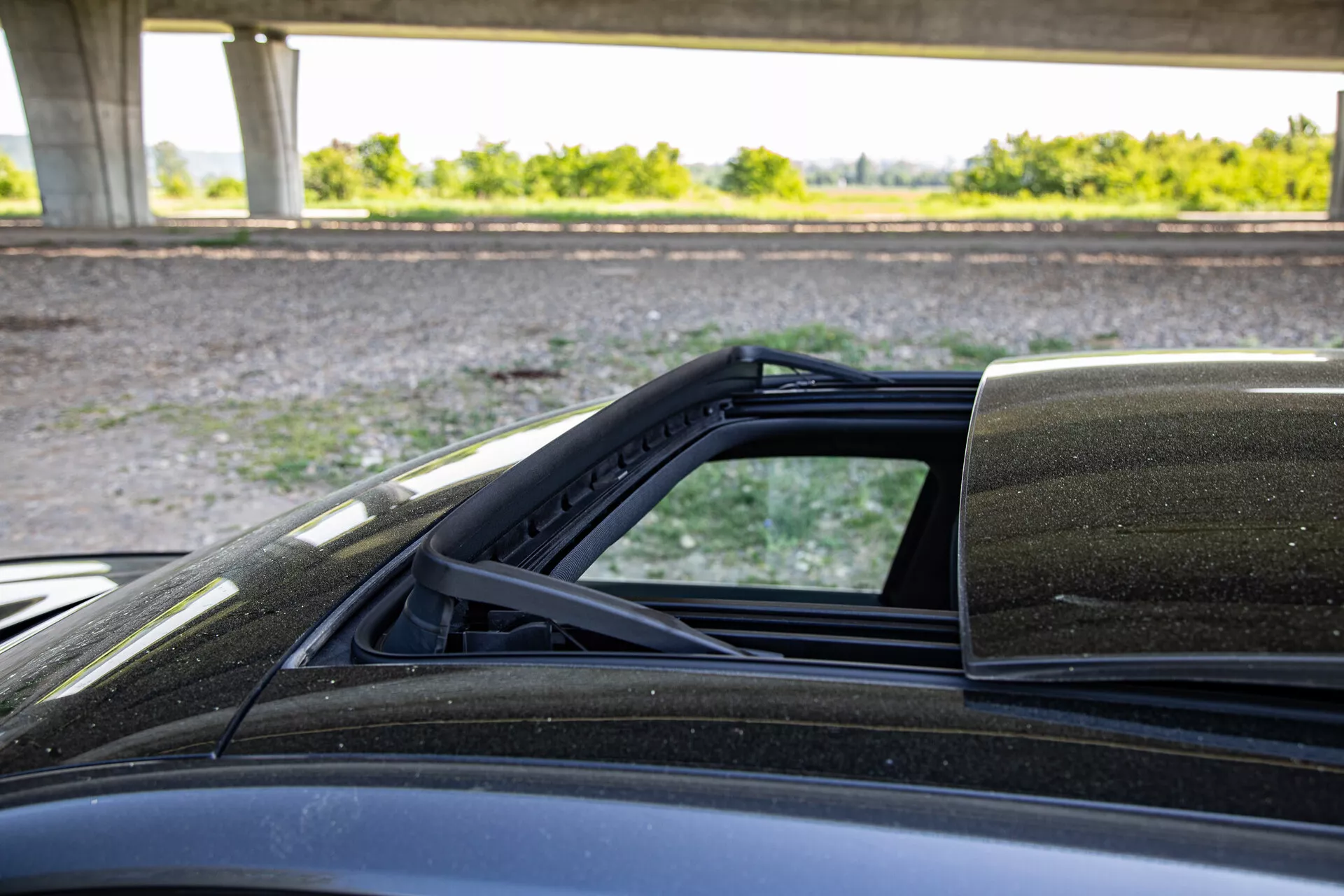 Vue détaillée du mécanisme du toit convertible de la Peugeot 408 2023, se concentrant sur les points de connexion à la carrosserie, prise du côté passager mettant en évidence la doublure intérieure du toit souple, le scellement contre les intempéries et la peinture extérieure.