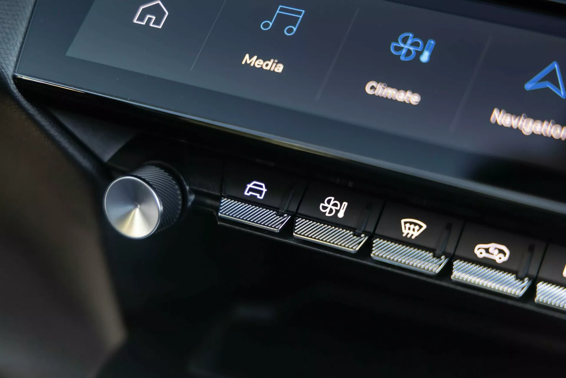 Interface de contrôle central de la Peugeot 408 2023 affichant des boutons tactiles illuminés et partie de l'écran tactile avec des icônes d'infodivertissement et de contrôle climatique, mettant en évidence la technologie avancée du véhicule