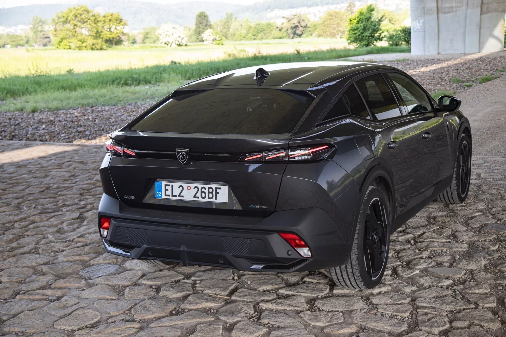 Peugeot 408 2023 capturée depuis un angle arrière de trois quarts mettant en lumière le design du véhicule, le pare-chocs arrière, les feux arrière et les jantes en alliage sportives