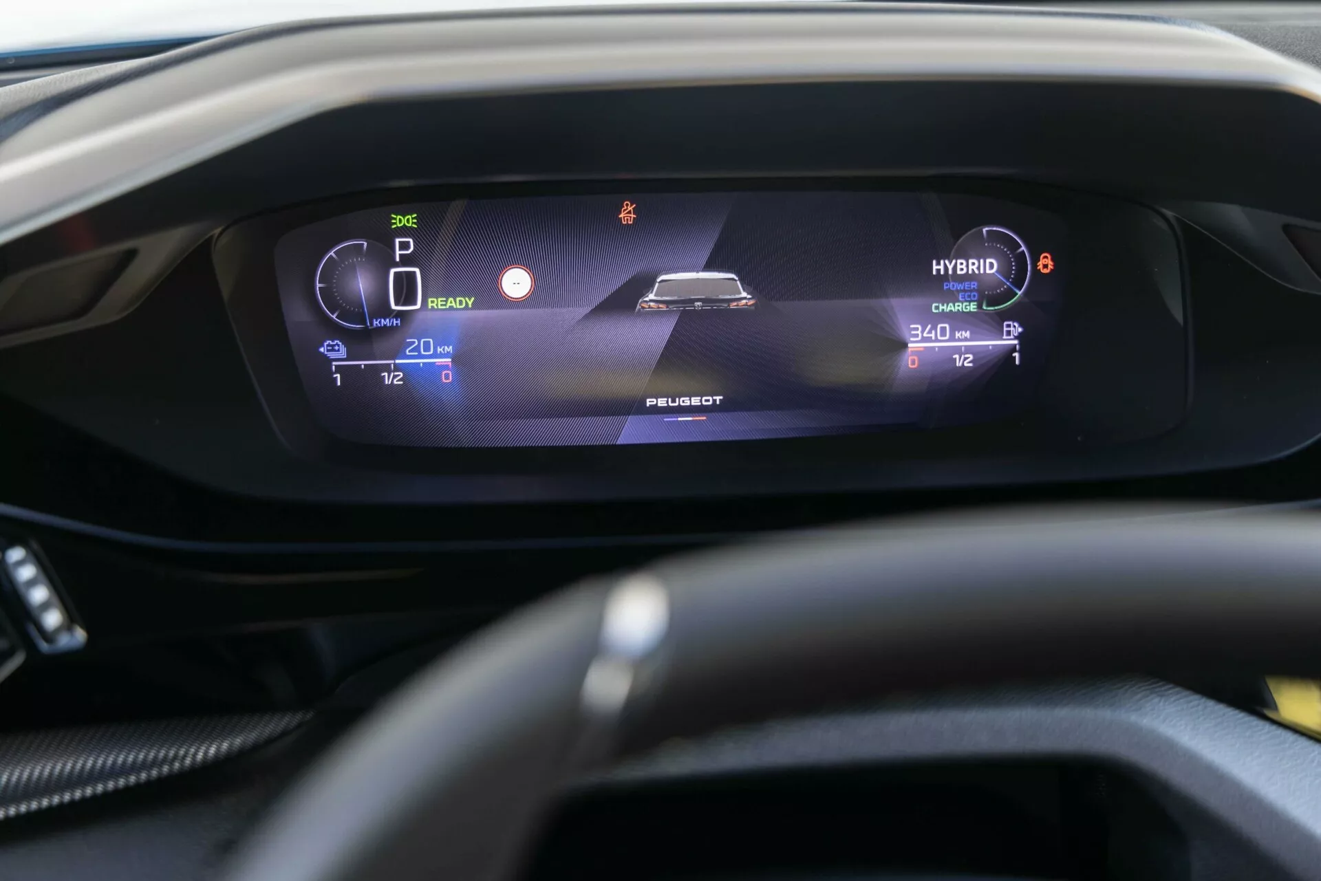 Vue intérieure rapprochée du Peugeot 408 2023 affichant le tableau de bord numérique du point de vue du conducteur, présentant des indicateurs hybrides tels que le mot ‘HYBRID’, mode parking, niveau de batterie, et autonomies, centrée sur l'affichage élégant et illuminé derrière le volant légèrement flou.