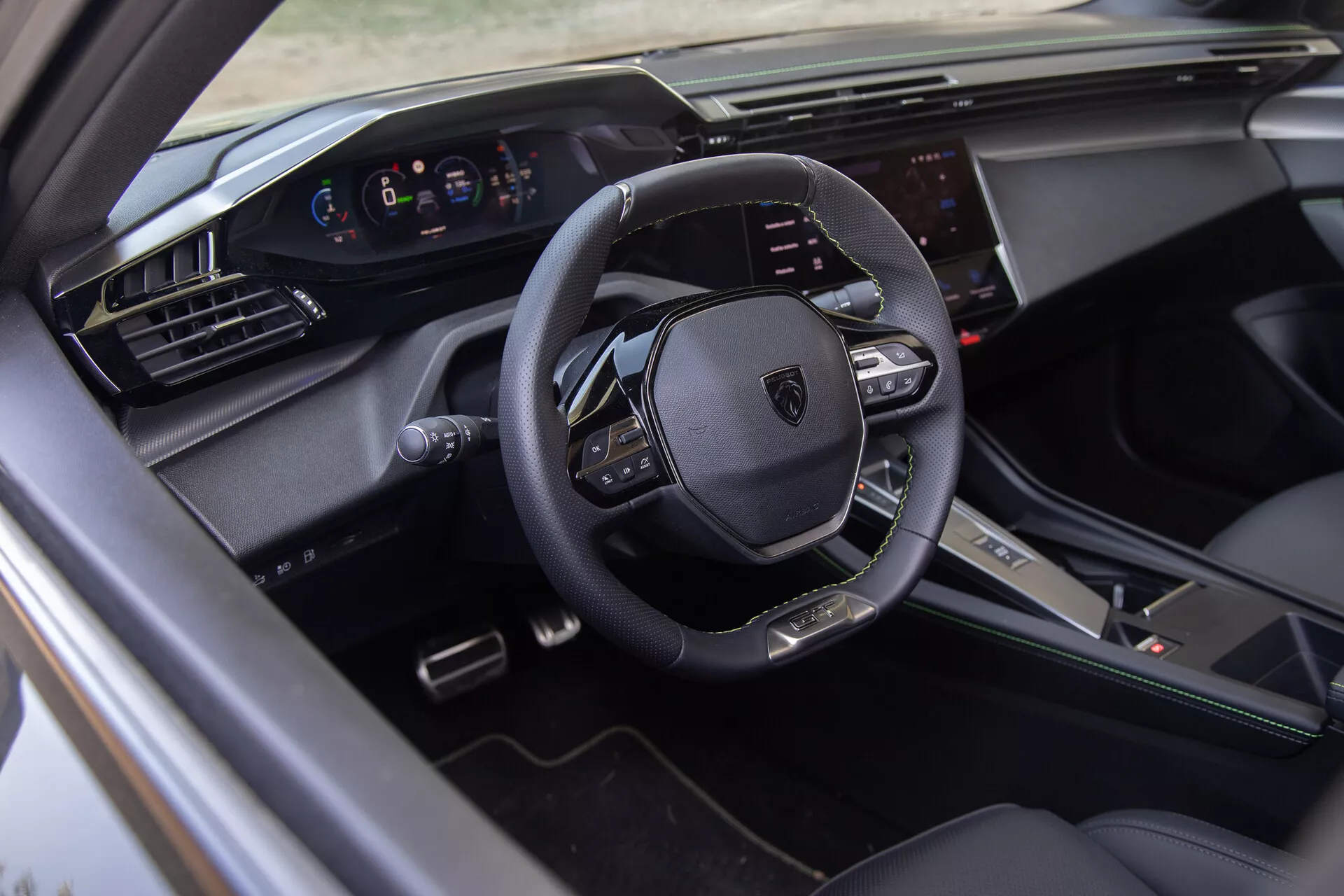 Intérieur du Peugeot 408 2023 montrant un volant multifonctions en cuir, cluster d'instruments numériques et système d'infodivertissement tactile du point de vue du côté conducteur