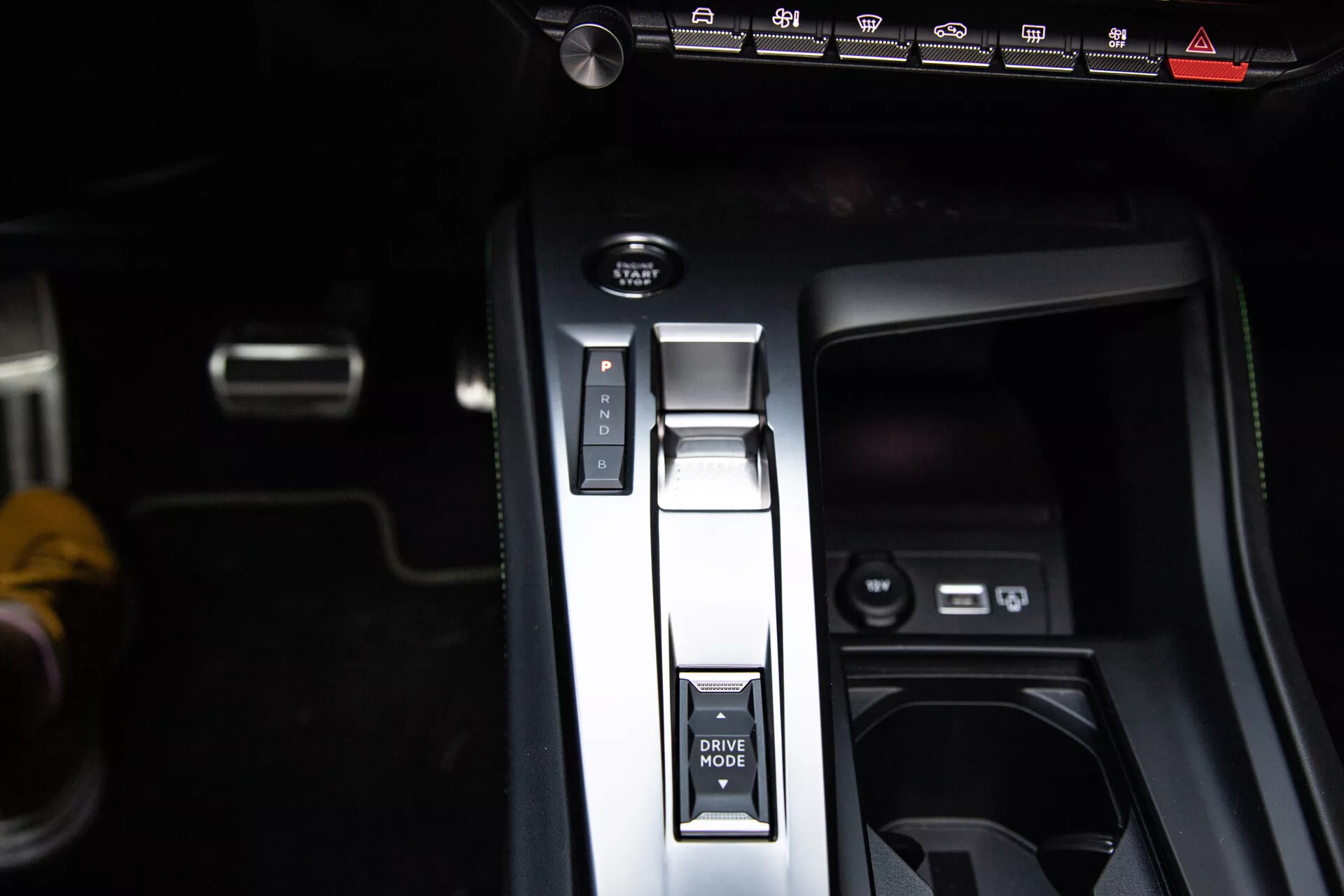 Vue rapprochée de la console centrale du Peugeot 408 2023 avec levier de vitesse en position Parking, bouton MODE DE CONDUITE, frein à main électronique et ports USB, démontrant un design intérieur moderne.