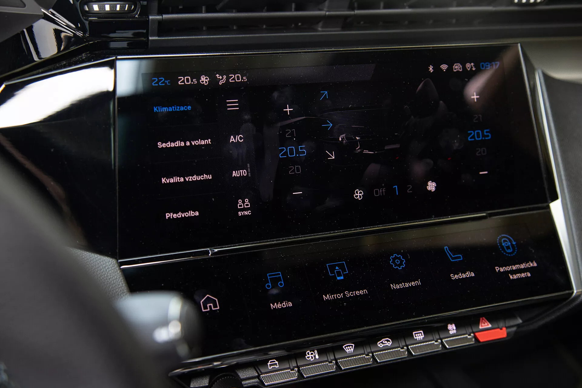 Console centrale de la Peugeot 408 2023 montrant le système d'infodivertissement tactile et l'interface de contrôle climatique avec réglages de température et fonctions avancées