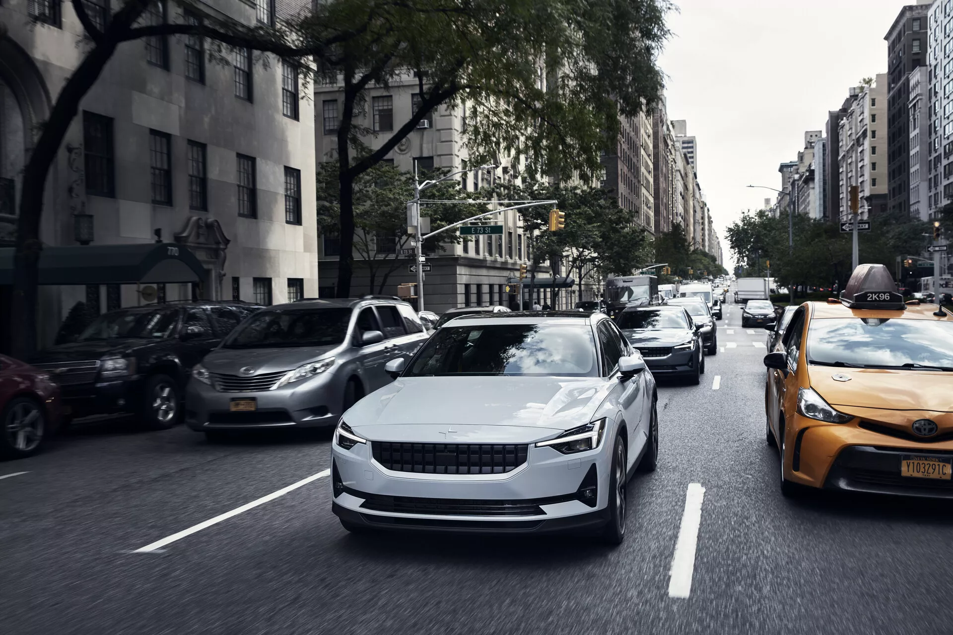 Vue de face d'une voiture électrique Polestar 2 de première génération de 2020 en mouvement, mettant en valeur son design élégant, ses courbes aérodynamiques et ses phares à LED modernes.