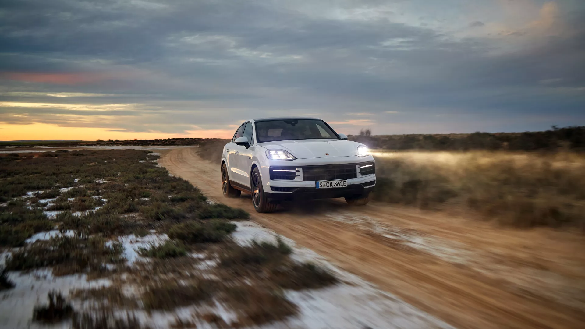 Modèle 2023 Porsche Cayenne 9YA Facelift roulant tout-terrain, présentant sa vue de face trois-quarts avec phares LED, suspension active et système de traction intégrale dans un cadre au crépuscule