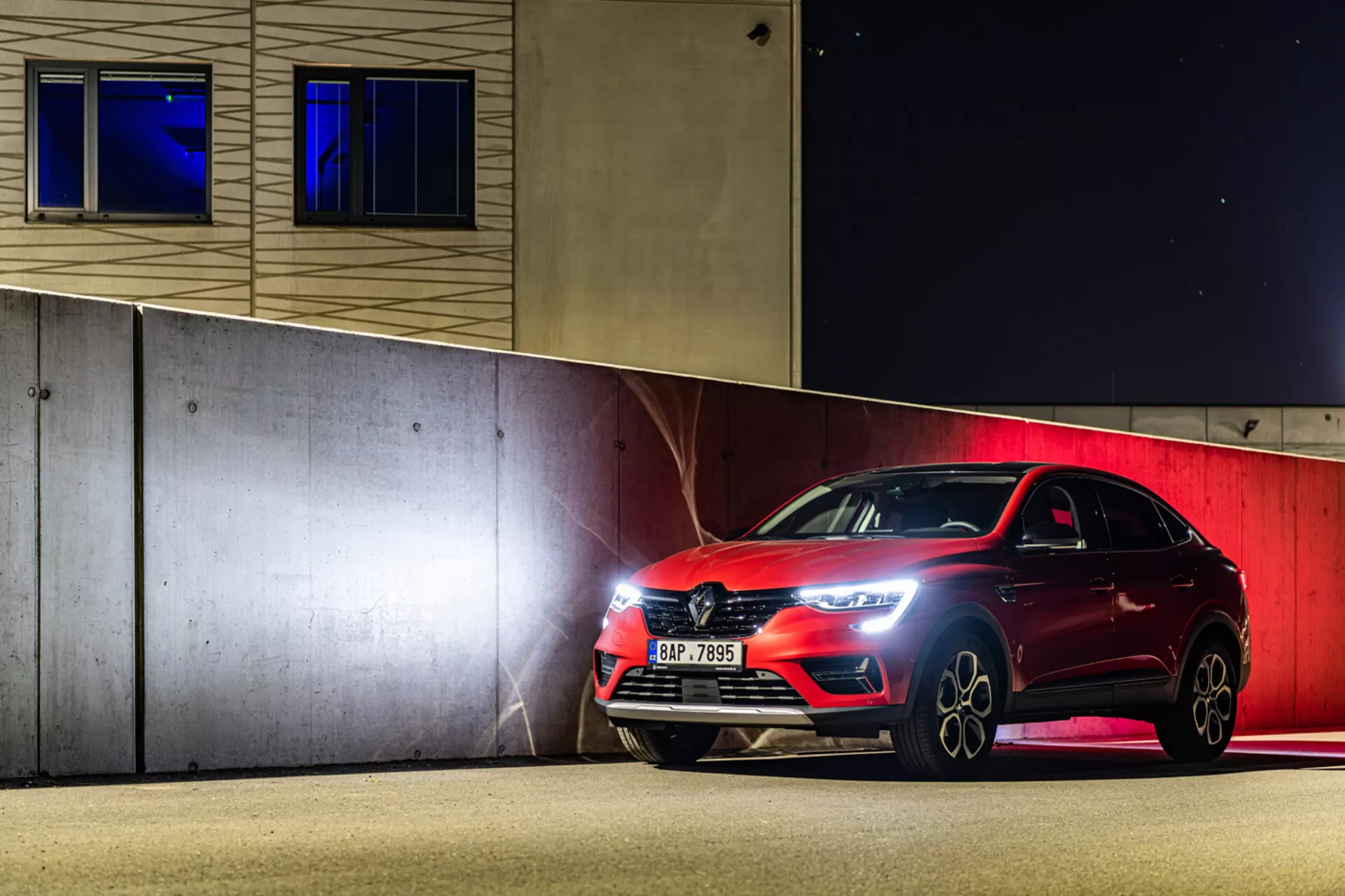 Hatchback sportif Renault Arkana 2021 garé la nuit, présentant des phares à LED, une grille avant et des roues en alliage sous un éclairage artificiel
