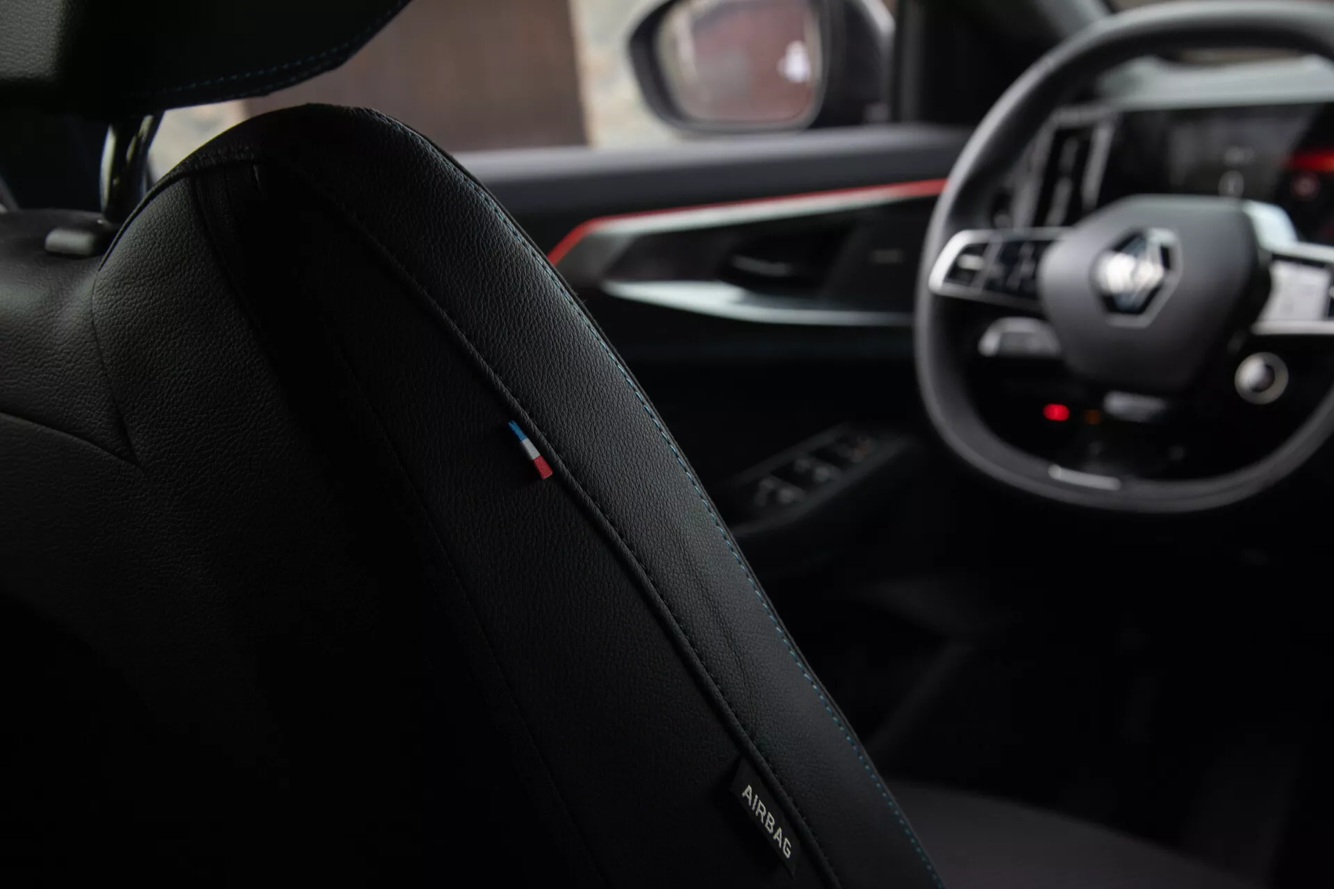 Vue intérieure depuis la perspective du passager arrière présentant le siège du conducteur avec logo BMW, garniture en cuir premium et coutures nuancées, se concentrant vers le tableau de bord avec emblème BMW sur le volant, cadrans analogiques et affichages numériques du système d’infodivertissement, ainsi qu'un aperçu du levier de vitesse et du panneau de contrôle multimédia dans une conception de cabine sophistiquée et ergonomique.