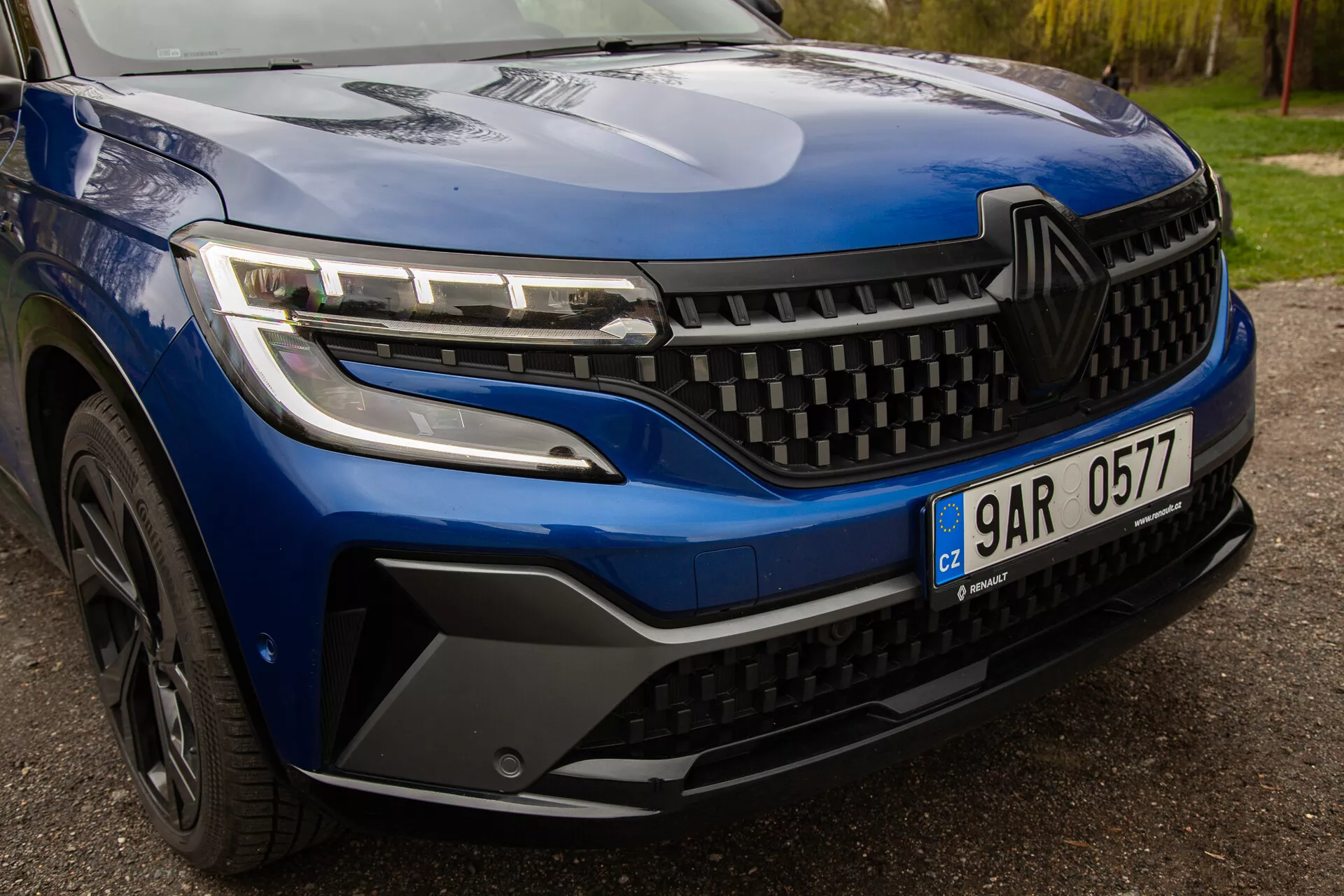 Vue rapprochée du Renault Austral 2022, montrant des phares LED élégants, un design de grille dynamique et un style détaillé du pare-chocs avant et de la roue, soulignant l'esthétique et la technologie modernes du véhicule.