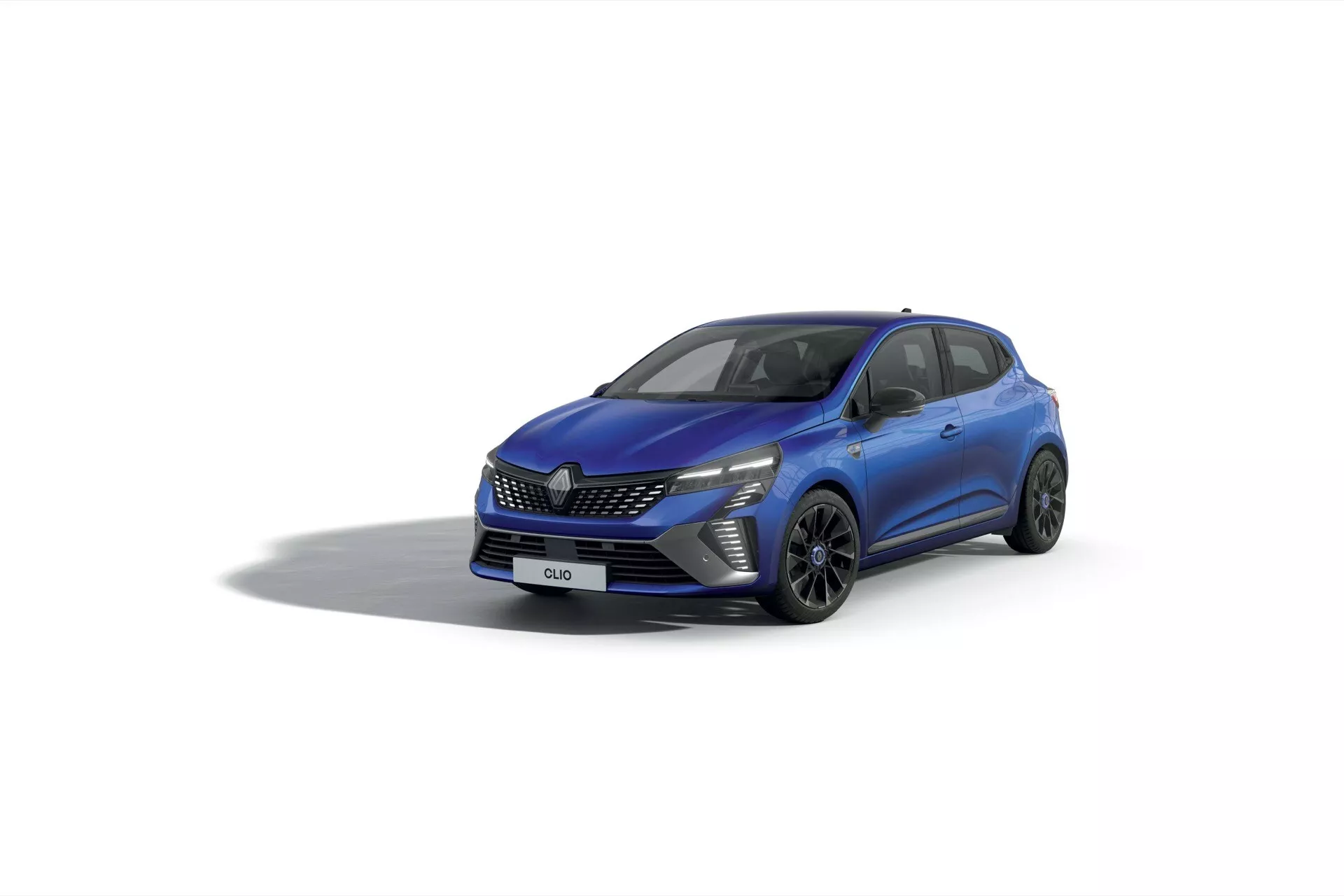 Renault Clio V-Facelift 2023 vue de trois quarts avant présentant des phares à LED, une grille à motif, des roues en alliage à multiples branches et des lignes de carrosserie dynamiques sur un fond de studio lumineux