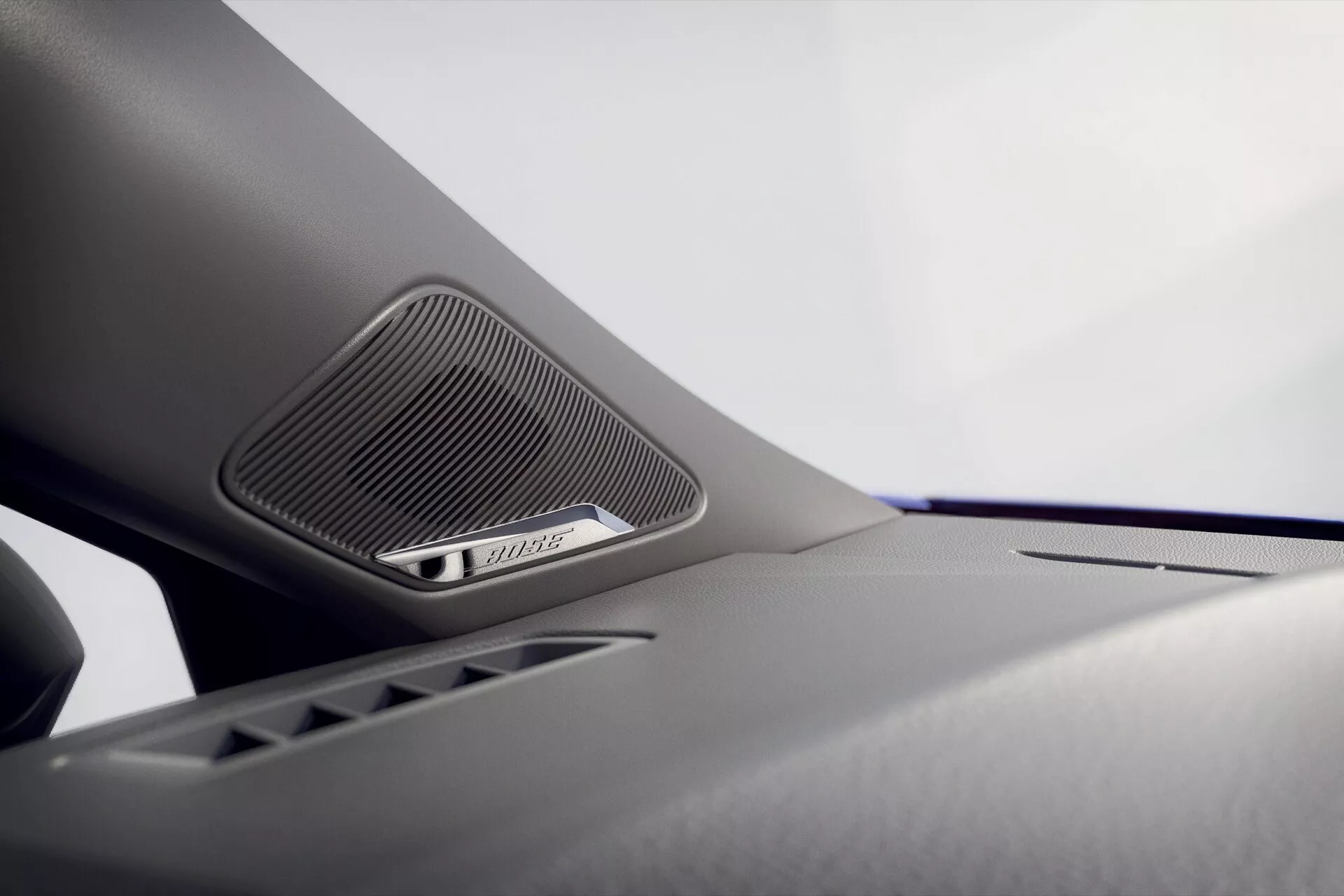 Gros plan sur le système de haut-parleurs intégré à l'intérieur du Renault Clio 2023 v-facelift, avec une grille triangulaire indiquant une qualité audio premium, mis en avant par les détails de conception intérieure du véhicule