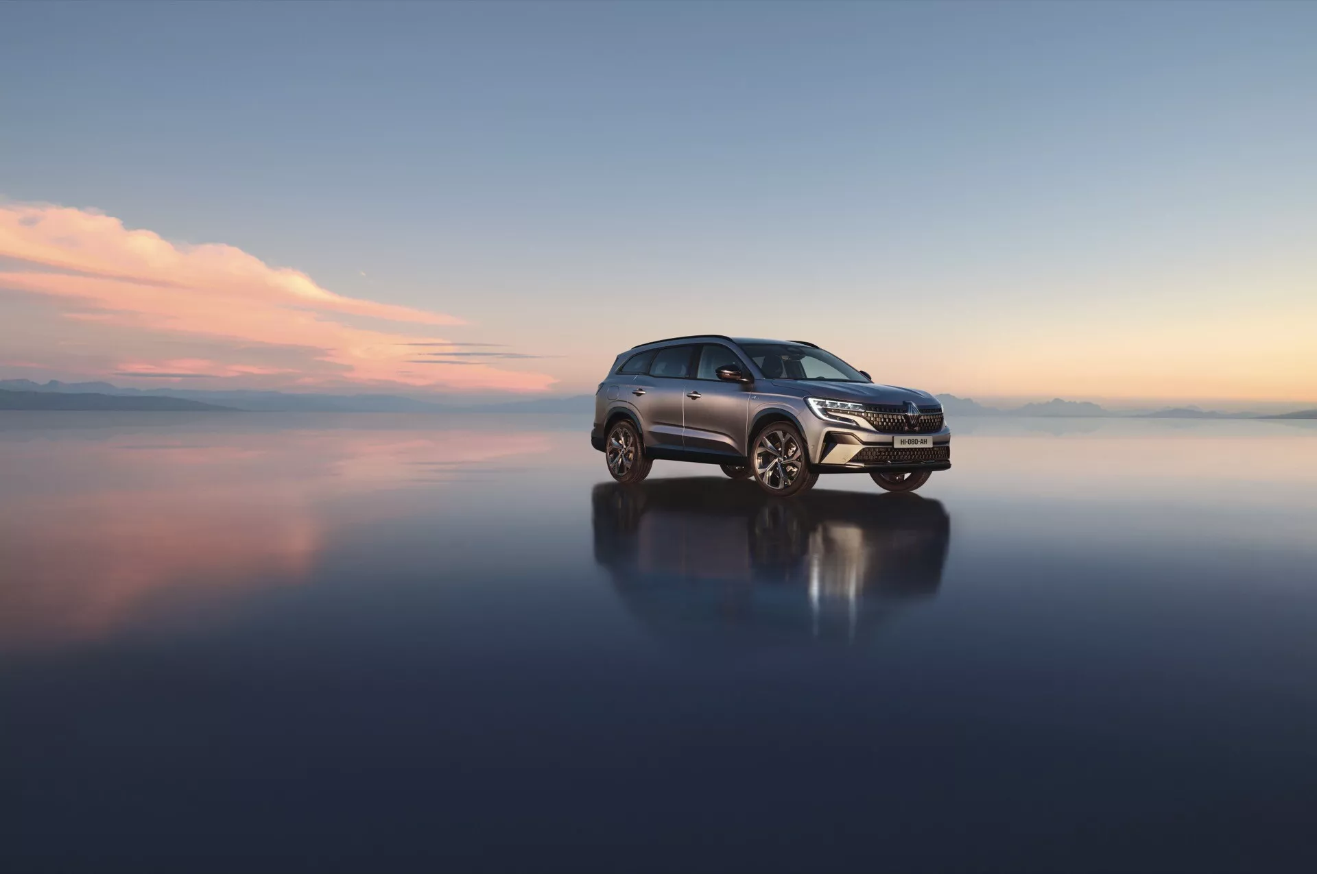 Renault Espace VI 2023 sur surface réfléchissante mettant en valeur la grille avant, les phares LED et les roues en alliage depuis une vue de trois quarts avant, soulignant le design aérodynamique et les caractéristiques technologiques avancées
