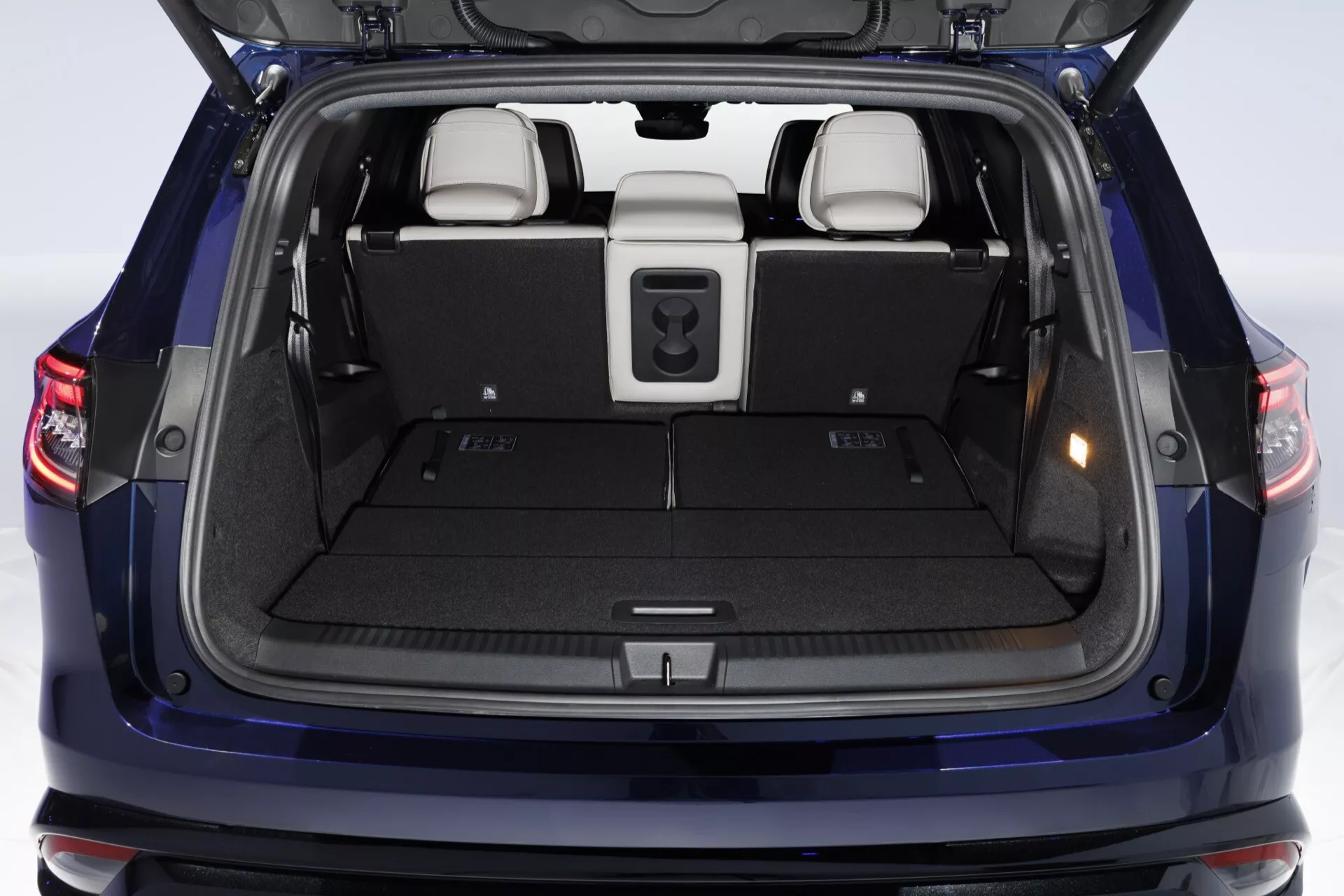 Vue arrière du Renault Espace 2023 mettant en évidence le coffre ouvert et l'espace de chargement avec une configuration intérieure détaillée et une perspective élevée