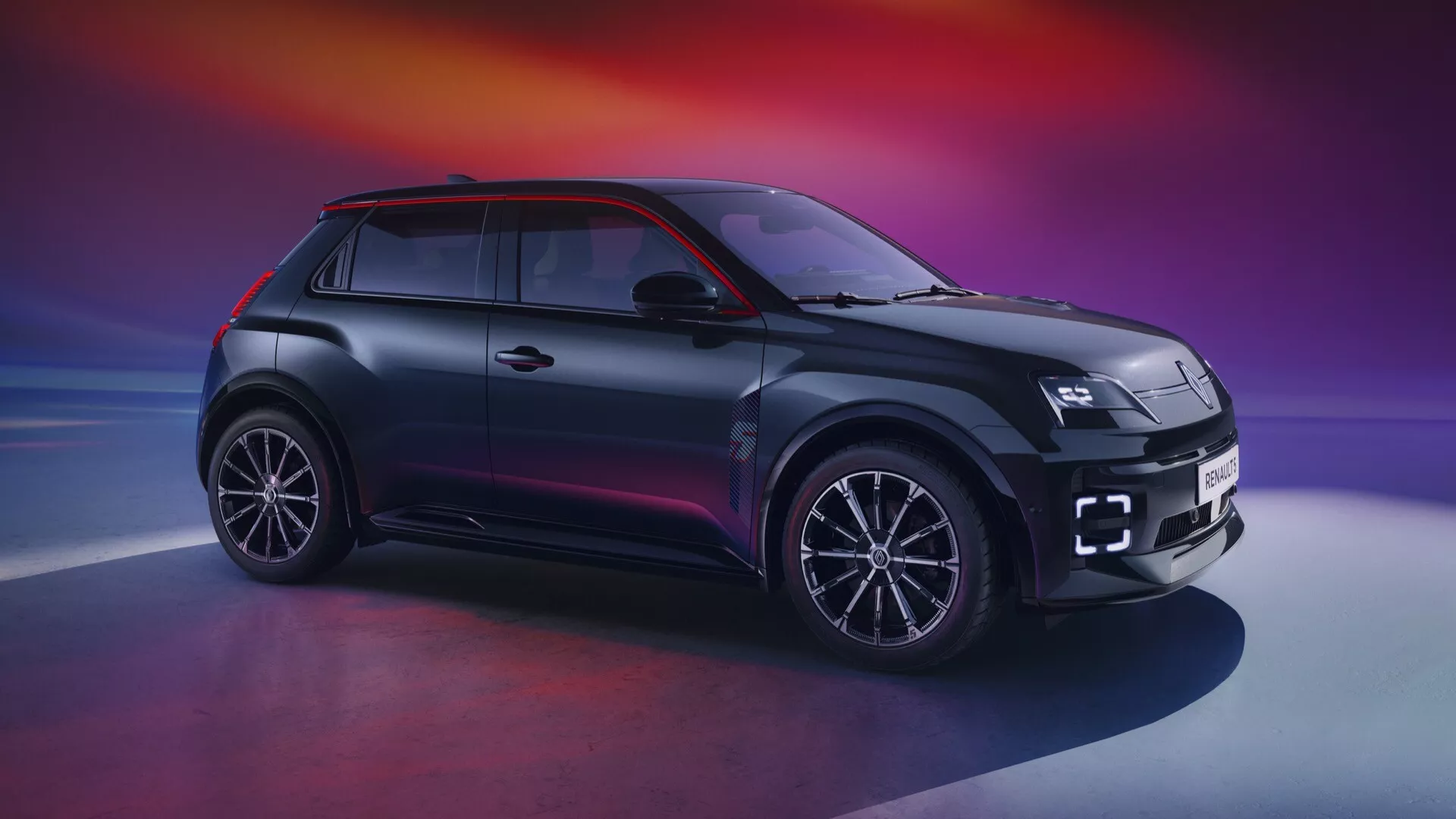 Vue avant-côté de la Renault R5 2024 présentant des phares LED, grille unique, jantes alliage à multiples branches, style de carrosserie SUV compact avec finition bicolore et design aérodynamique sur un arrière-plan dégradé violet-orange
