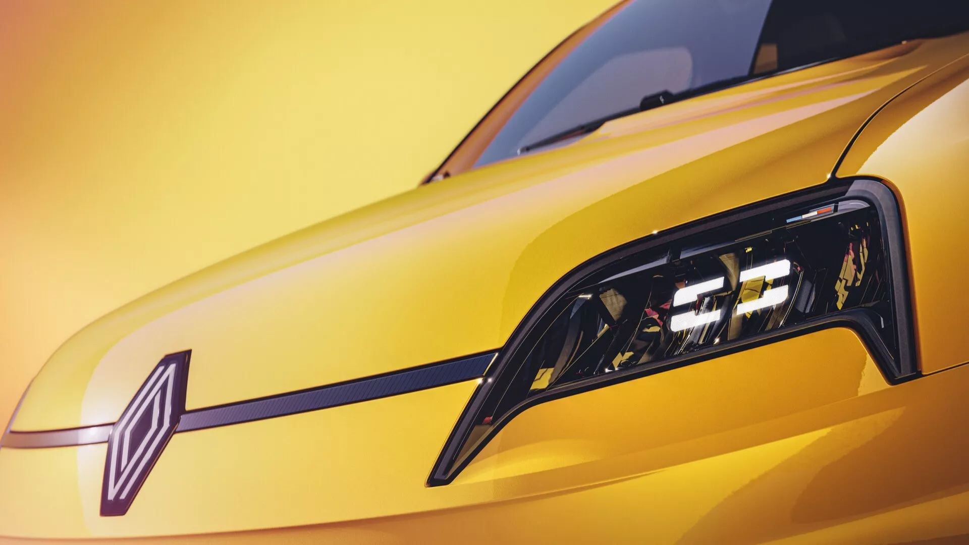 Gros plan sur l'avant du Renault R5 2024 montrant des phares LED élégants, une peinture jaune vibrante et un design de grille dynamique