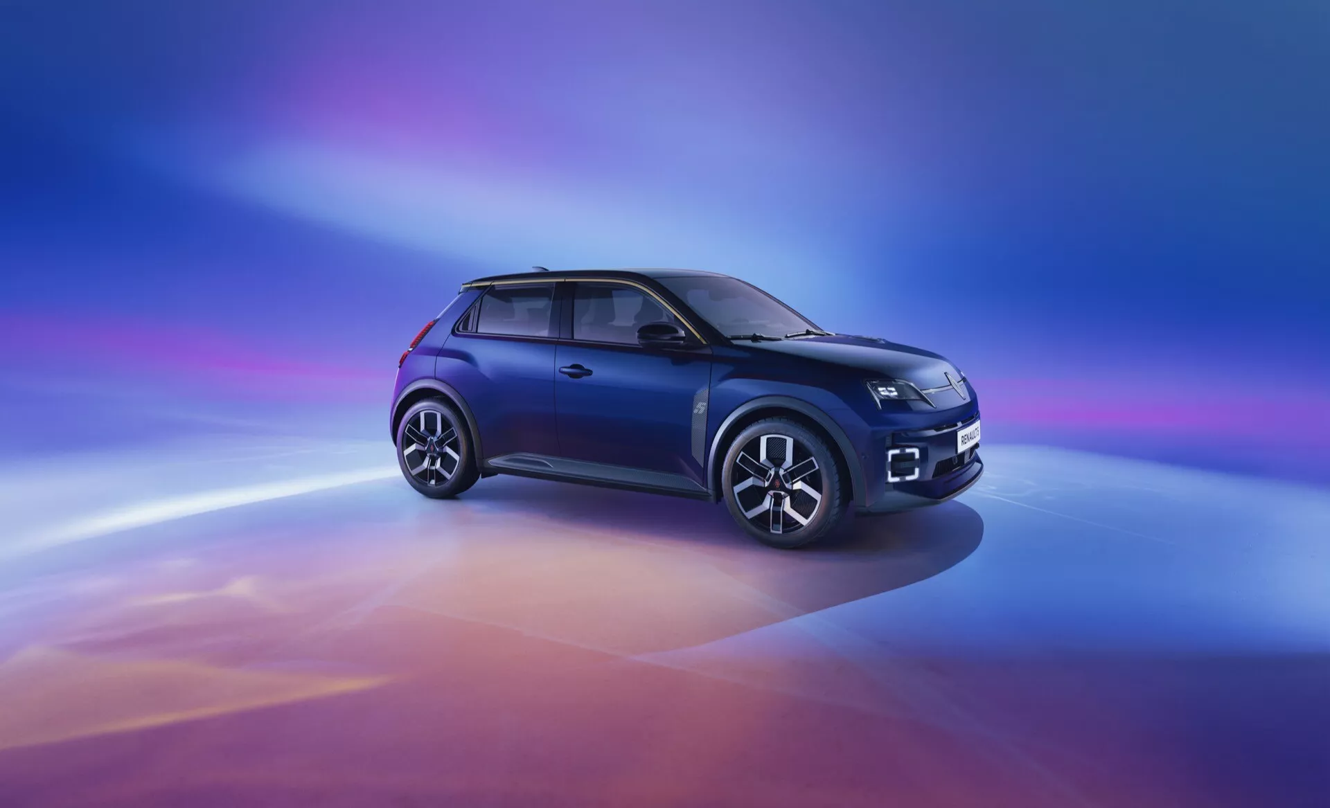 SUV compact Renault R5 2024 en bleu métallique présentant une vue de trois quarts avant montrant les phares LED, la grille de calandre avec accent en chrome et logo, les lignes aérodynamiques sur le capot, le profil latéral avec jantes alliage à multiples branches, entourage des fenêtres en chrome, et vitres teintées foncées, sur fond dégradé numérique passant du violet au bleu, puis à l’orange et au rouge