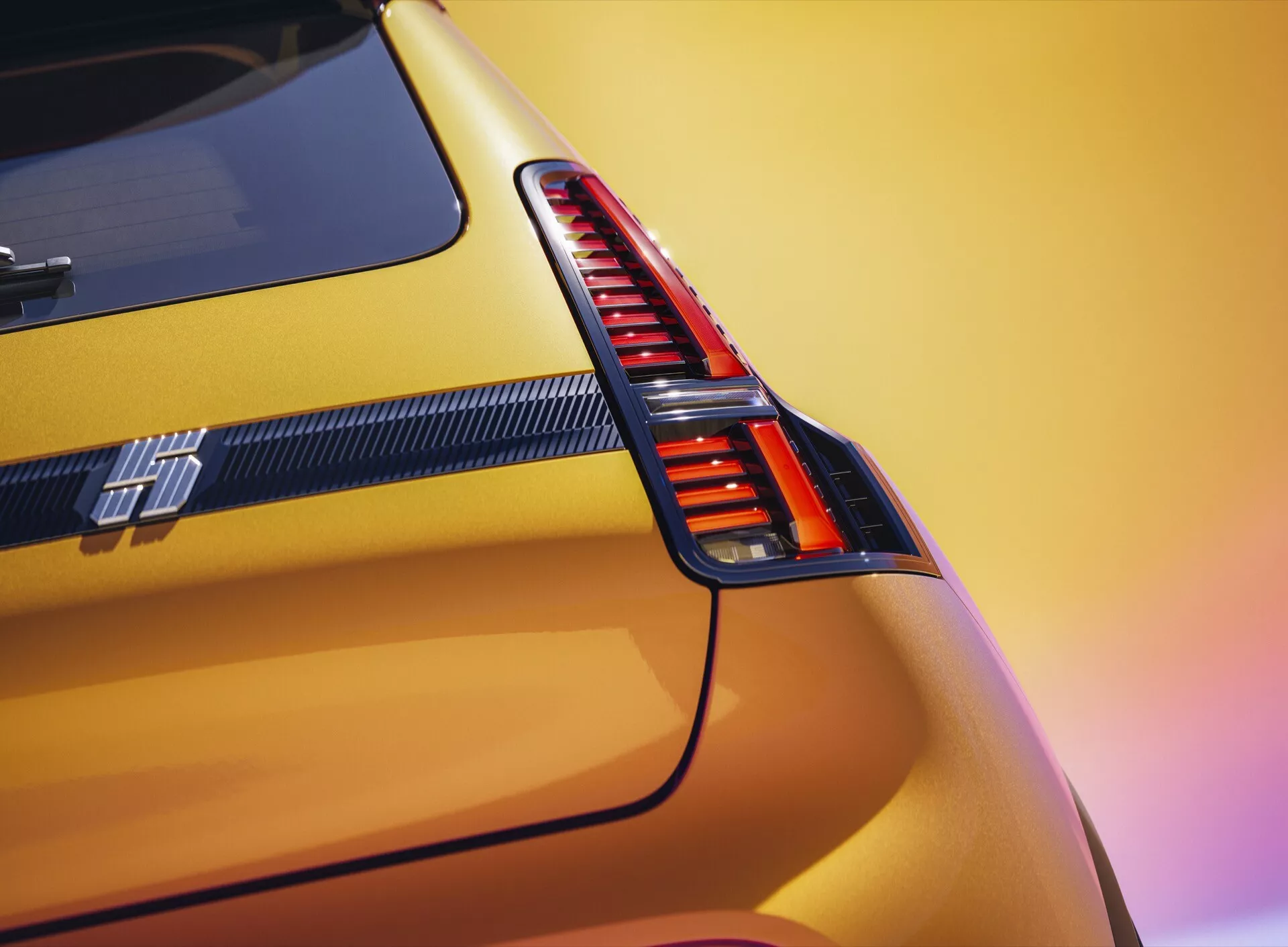Vue rapprochée de la section arrière du modèle Renault R5 2024 mettant en évidence son feu arrière LED rouge vertical, sa peinture jaune métallique éclatante et un emblème distinctif de la ligne de performance situé sous le feu arrière, avec un accent en fibre de carbone contre un fond de coucher de soleil flou.