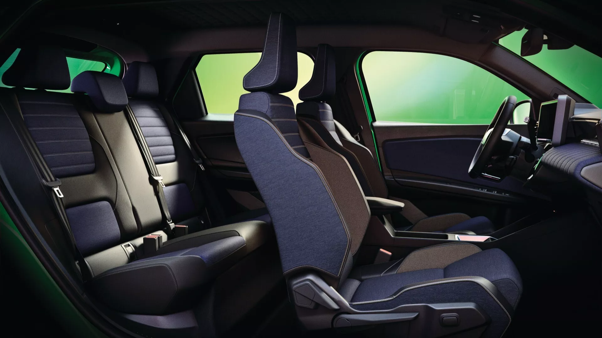 Vue intérieure du Renault R5 2024 mettant en lumière l'agencement ergonomique des sièges en cuir et tissu bicolores depuis une perspective latérale, montrant les sièges avant et arrière avec des caractéristiques intégrées dans le panneau de porte