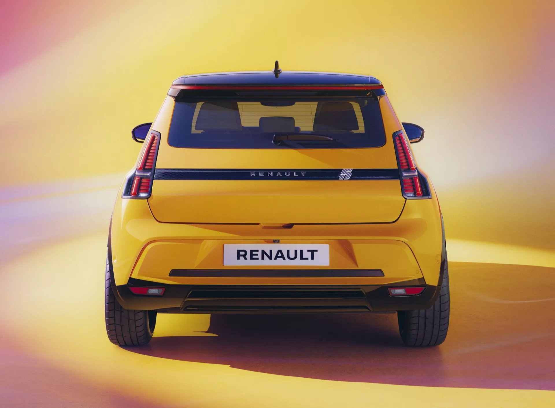 Vue arrière de la Renault R5 2024 mettant en avant hauteur, design arrière avec feux arrière LED en forme de C, badge RENAULT, et peinture métallisée dans un cadre de studio doucement éclairé
