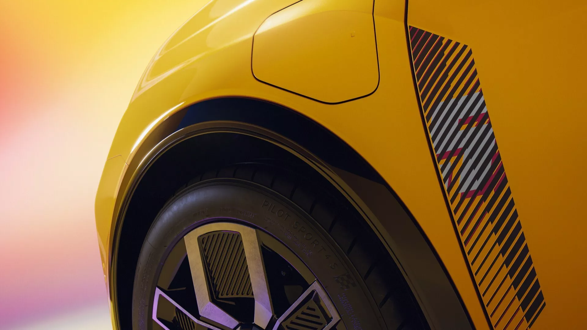 Vue arrière rapprochée de la Renault R5 2024 en jaune vibrant, mettant en avant l'aérateur arrière angulaire et le design moderne de la roue bicolore, soulignant la carrosserie orientée vers la performance et le pneu à profil bas.