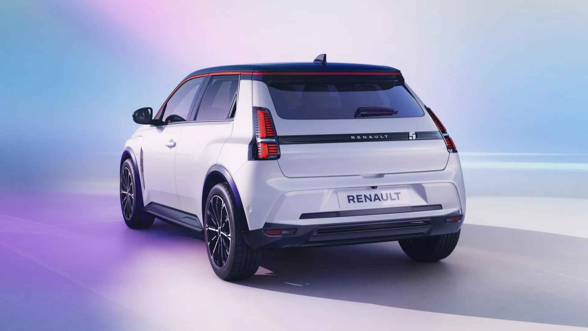 Vue arrière trois quarts d'un SUV Renault R5 2024 blanc sur un fond dégradé rose à bleu, soulignant le design moderne du véhicule avec des feux arrière LED, des garnitures de carrosserie noires, des roues en alliage à finition foncée, un becquet de toit et une antenne aileron de requin, sous un éclairage de studio.