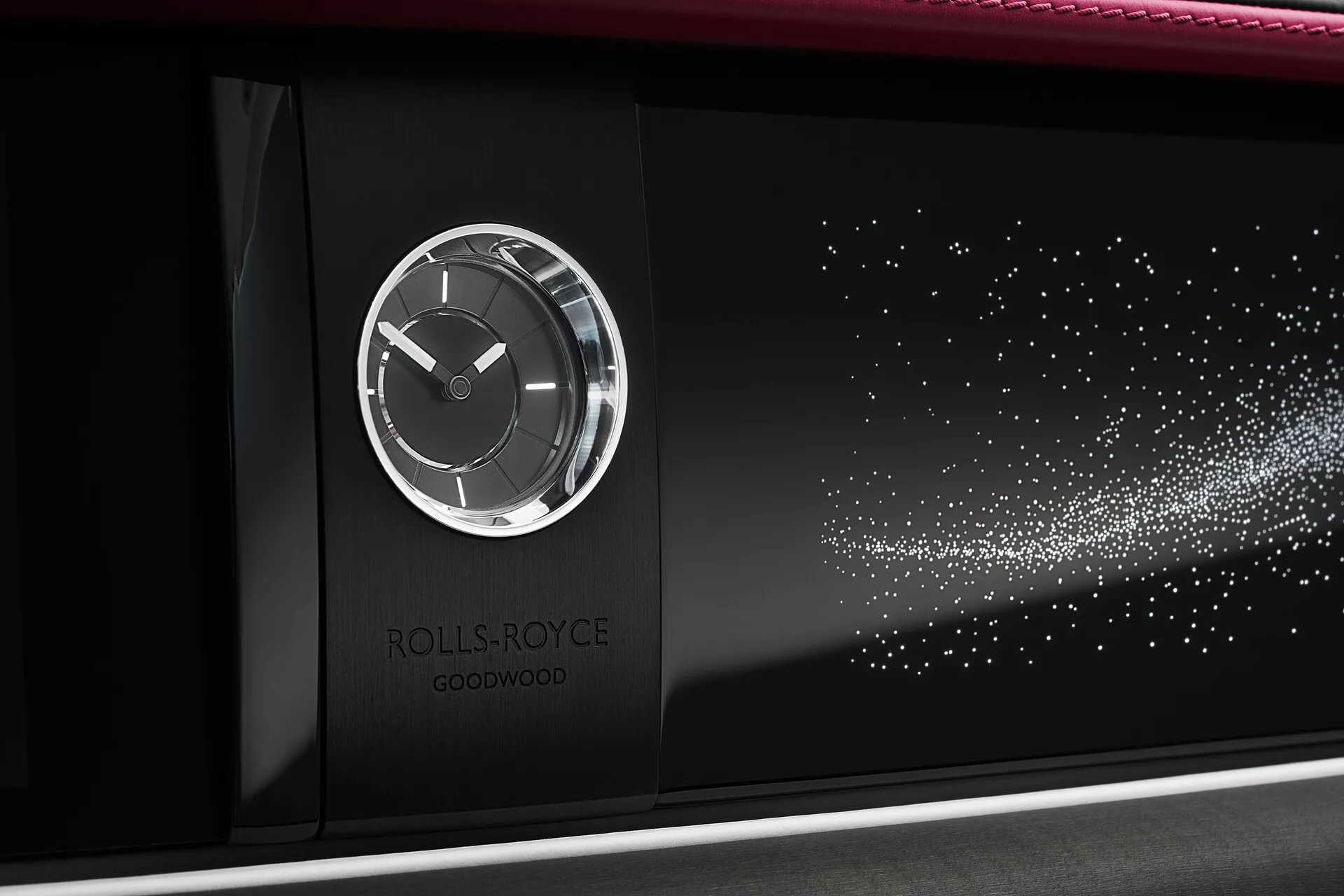 Gros plan sur le tableau de bord de la Rolls-Royce Spectre 2023 montrant une horloge analogique dans un boîtier métallique avec le logo au centre et une caractéristique de motif étoilé contre un fond noir brillant, indiquant une personnalisation et un design de luxe.