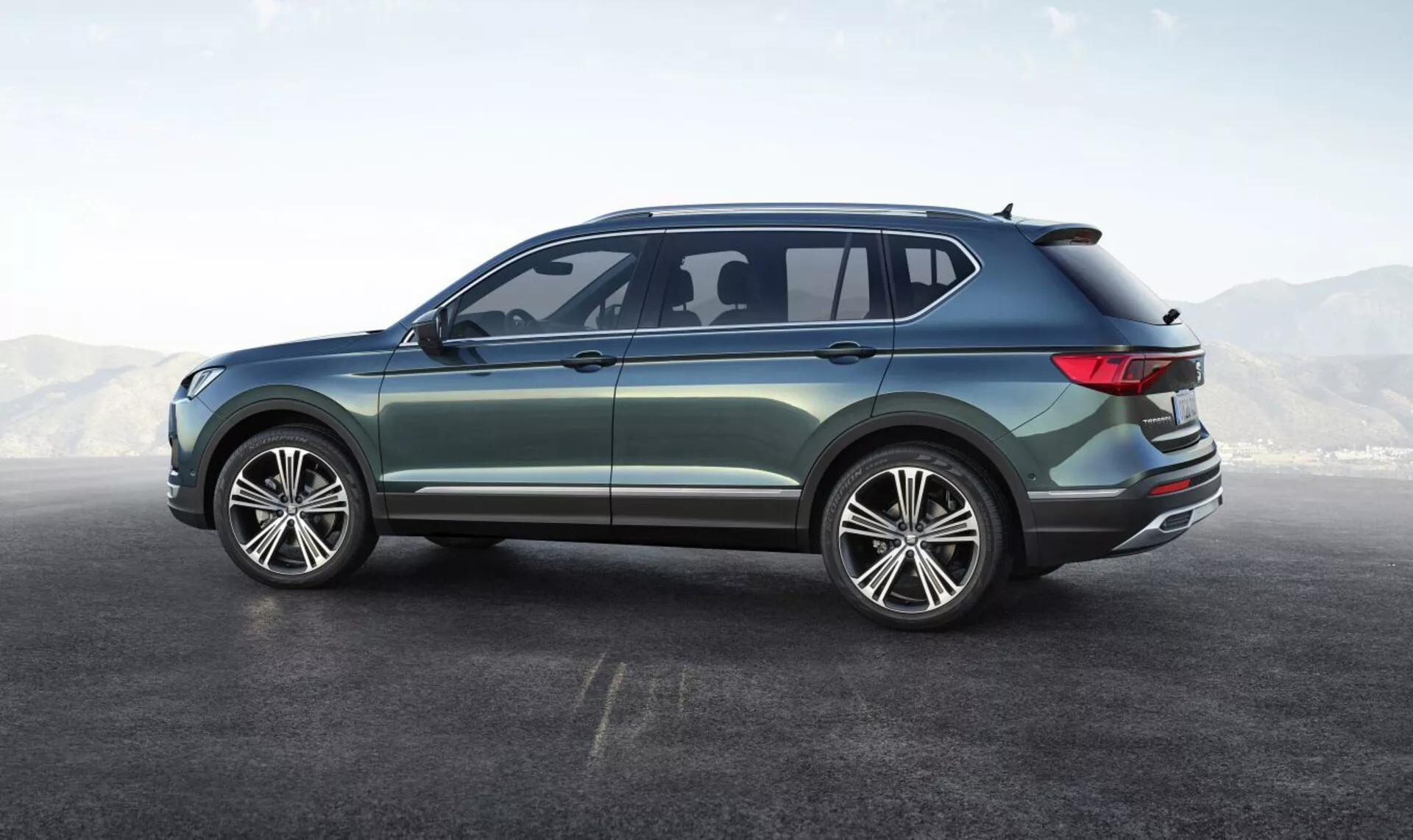 SUV moderne Seat Tarraco 2019 depuis une perspective arrière de trois quarts montrant un design élégant, des feux arrière enveloppants LED, de grandes roues en alliage, et des fonctionnalités technologiques avancées dans un environnement de studio
