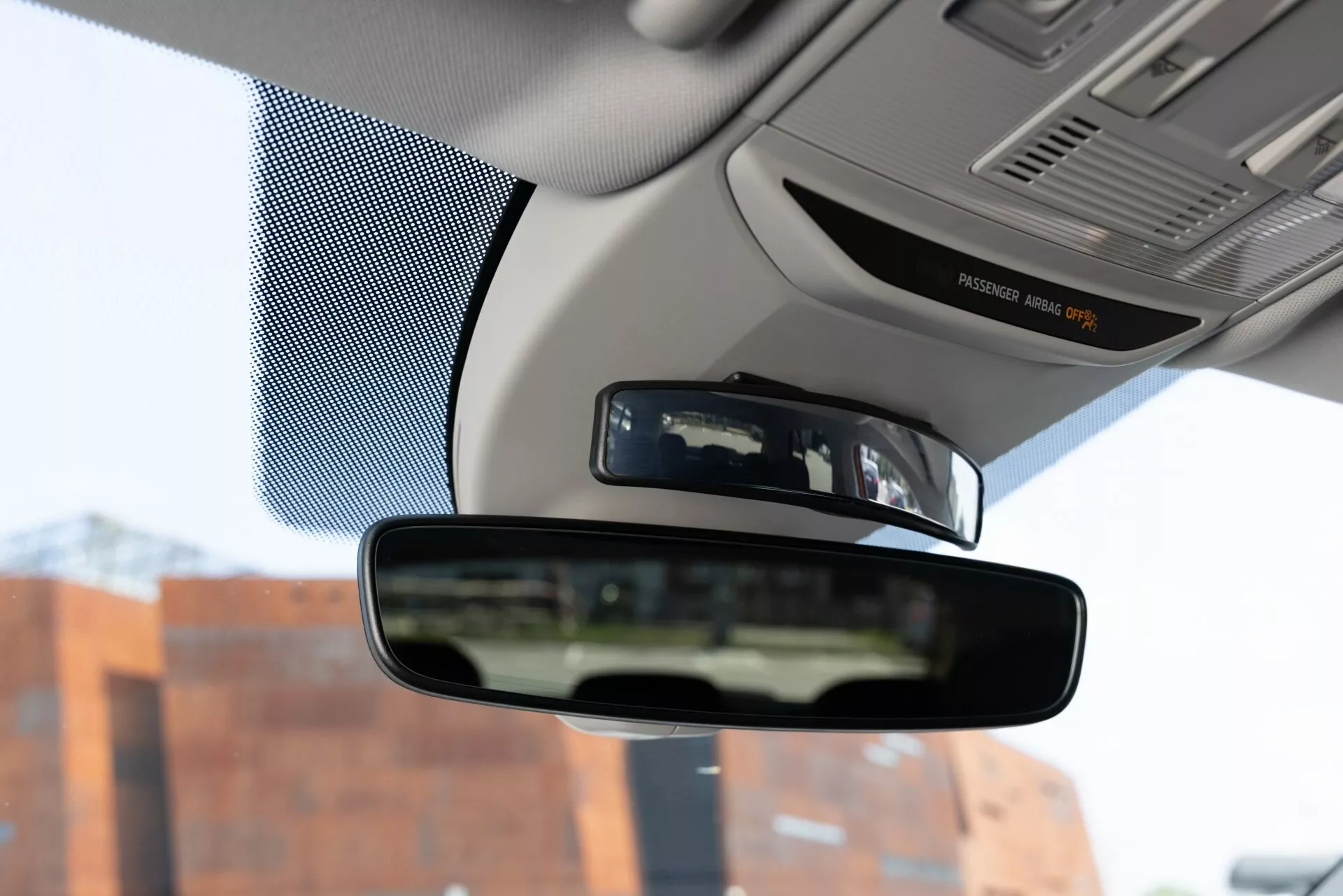 Vue intérieure de la Skoda Fabia 2021, centrée sur le rétroviseur depuis la perspective du siège conducteur, capturant le rétroviseur, des parties du tableau de bord et les bords du pare-brise.