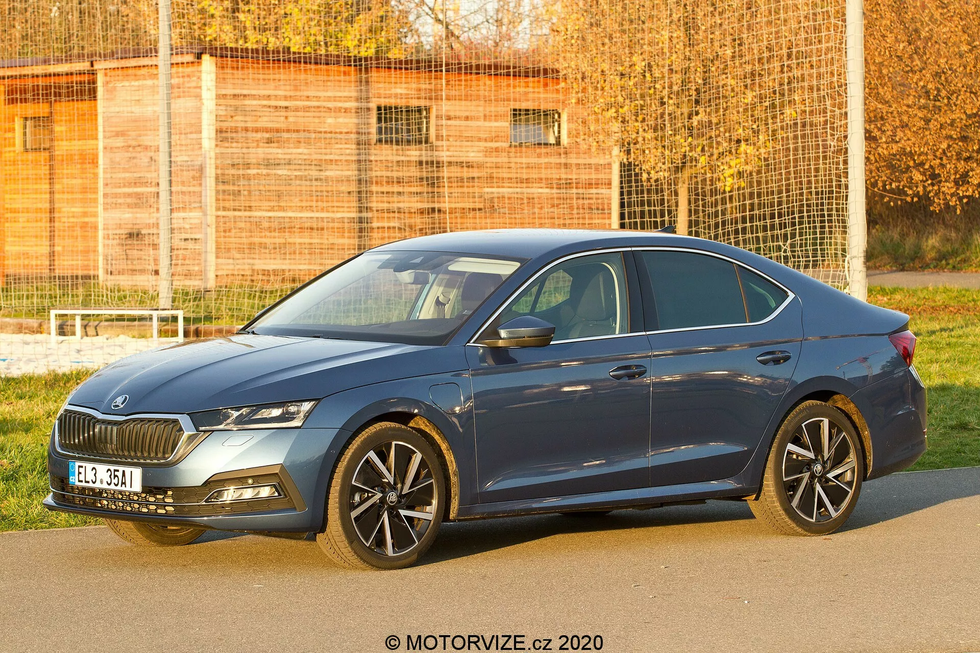 Image d'une berline quatre portes Skoda Octavia 2020 prise sous un angle avant trois quarts, montrant sa calandre avant, ses phares, son capot, ses roues, la portière du conducteur et une partie de l'arrière. Le cliché capture le design distinctif de la calandre, les élégants phares probablement équipés de systèmes d'éclairage LED ou adaptatifs, les jantes en alliage à plusieurs rayons évoquant sportivité ou luxe, les pneus à profil bas et les rétroviseurs latéraux avec clignotants intégrés. Les lignes aérodynamiques de la carrosserie et la couleur bleue de la voiture sont clairement visibles, soulignant les éléments de design et de technologie adaptés aux contextes automobiles et de véhicules modernes.