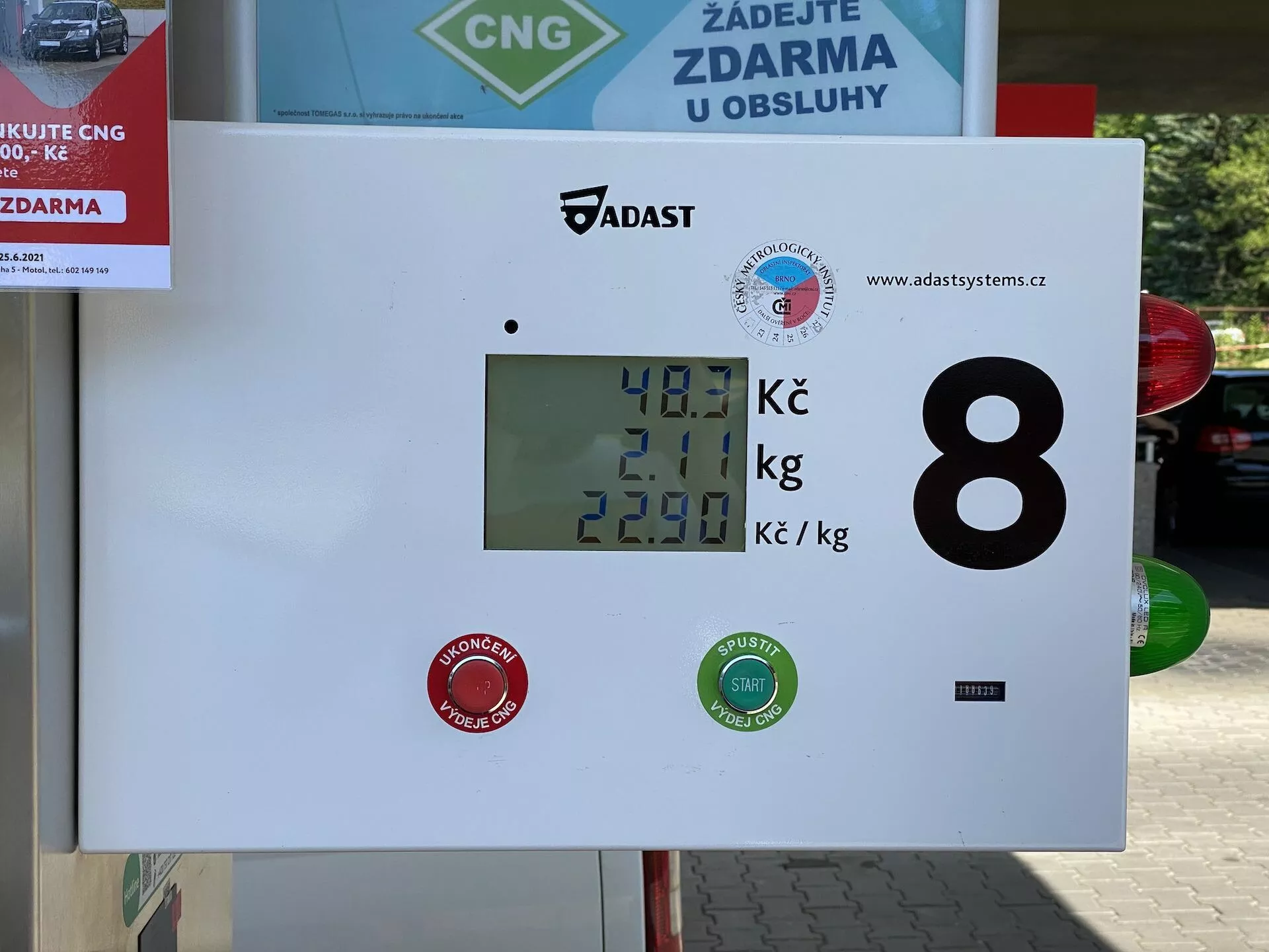 Affichage du distributeur de gaz naturel comprimé (GNC) dans une station-service montrant 40,1 Kč pour la quantité de carburant, 2,01 kg comme poids du gaz et un prix par kilogramme de 22,90 Kč. L'affichage comprend des logos de marque et l'identificateur numérique 8, avec un cadre extérieur indiqué par un panneau de lavage de voiture ou de service en arrière-plan.