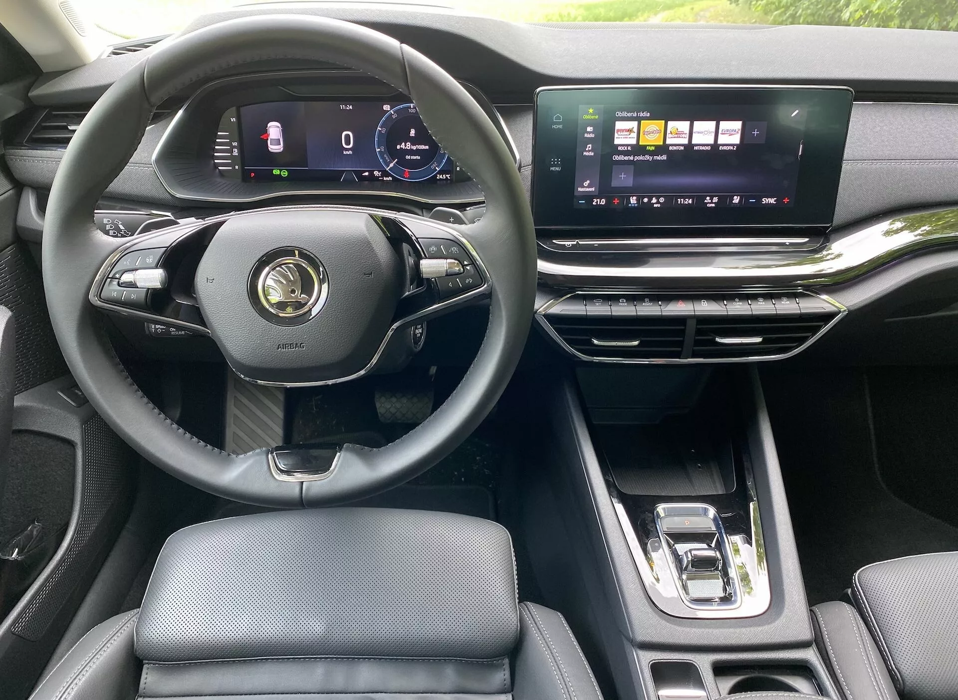 Intérieur d'une Skoda Octavia Limousine 2020 moderne, mettant en évidence la perspective du conducteur avec un volant multifonction à trois branches, tableau de bord numérique, écran tactile d'infodivertissement horizontal large, aérateurs élégants et levier de vitesses automatique. L'intérieur luxueux présente des sièges en cuir et des accents métalliques.