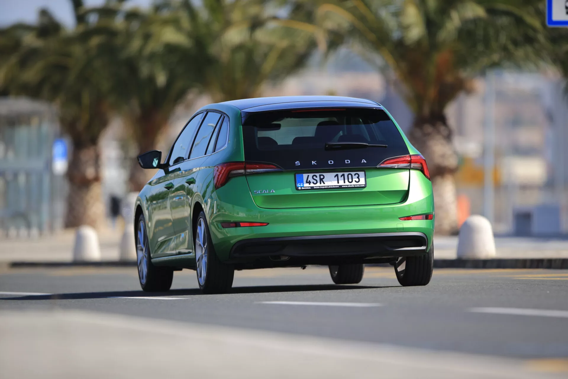 Škoda Scala 2019 en mouvement vue de l'arrière, mettant en avant des caractéristiques de design moderne comme les feux arrière LED, l'aileron arrière intégré et les embouts d'échappement jumeaux, capturée d'un point de vue dynamique en contre-plongée.