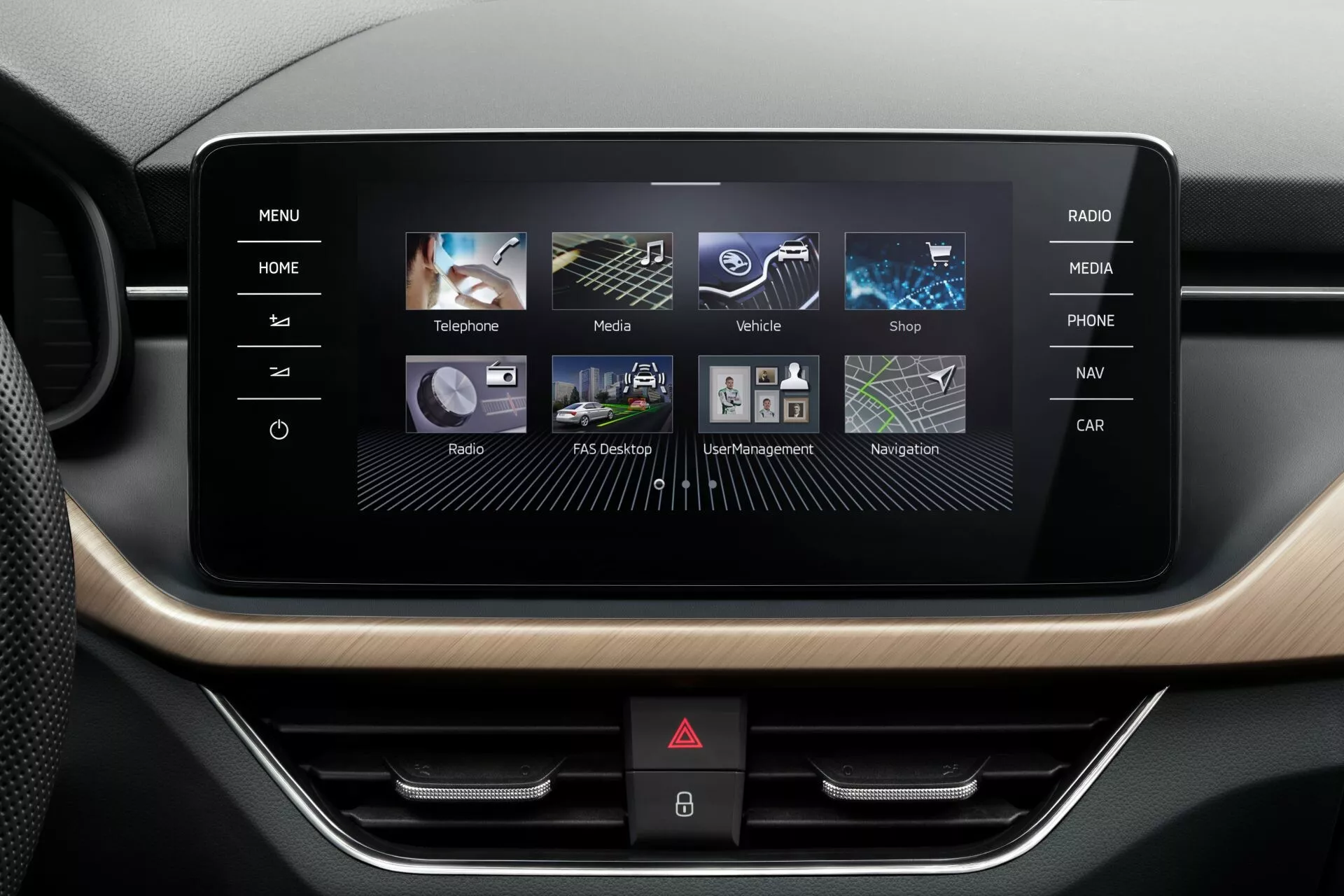 Console centrale de la Skoda Scala 2019 avec écran du système d'infodivertissement orienté paysage, affichant des icônes de téléphone, média, réglages du véhicule, boutique, radio, navigation et assistant, entourées d'une finition en métal ou grain de bois et boutons physiques en dessous.