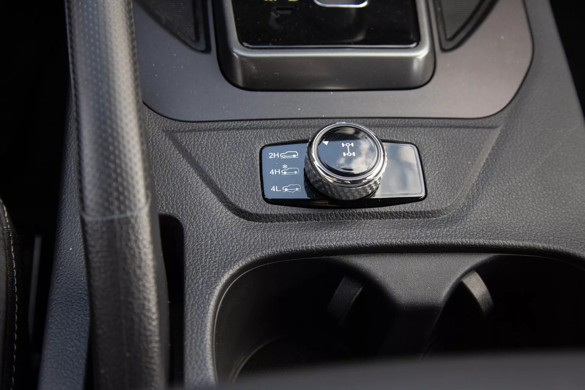 Vue rapprochée de la console centrale du SsangYong Musso 2022 mettant en évidence le sélecteur de contrôle 4WD sur 2H, englobant un design intérieur moderne et des caractéristiques pratiques