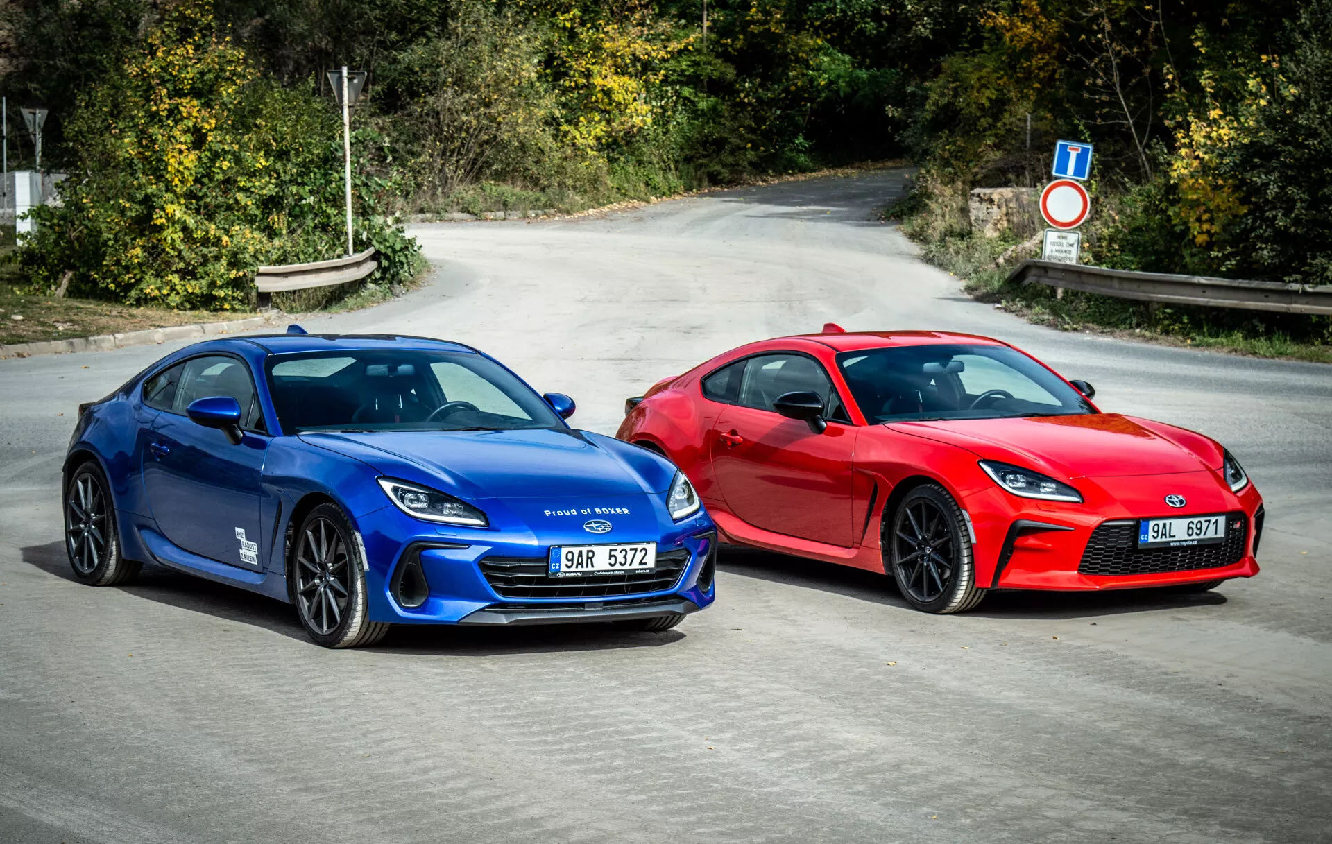 Duo de Subaru BRZ 2023 présentant des voitures sportives style coupé en bleu vibrant et rouge saisissant garées côte à côte sur l'asphalte avec des éléments de design aérodynamique, des phares LED modernes et des roues orientées vers la performance sous la lumière naturelle du jour