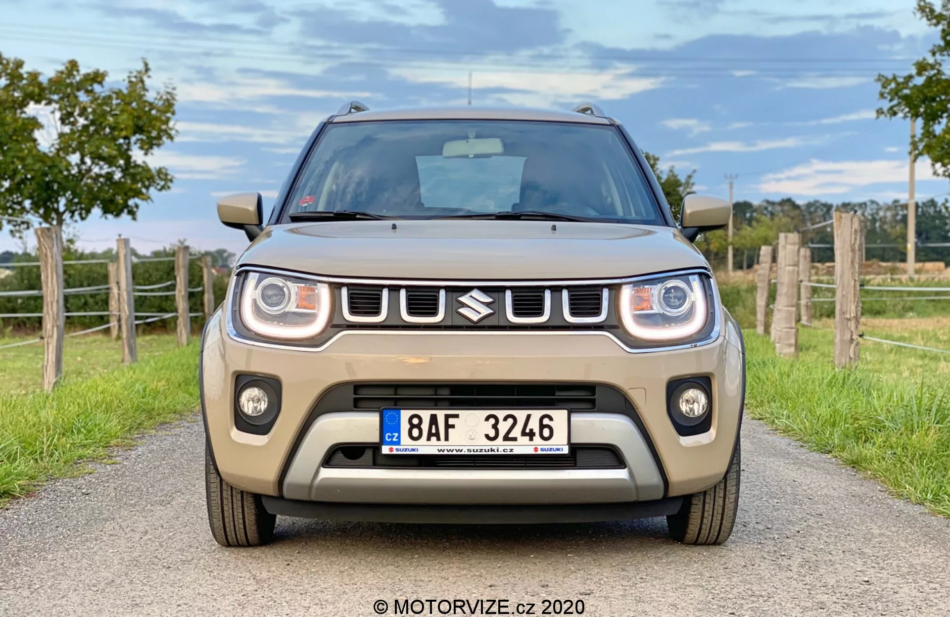 Vue de côté avant de la Suzuki Ignis 2020 1.2 Dualjet Hybrid Club dans un environnement urbain, mettant en avant son design compact, ses phares modernes et sa calandre audacieuse.