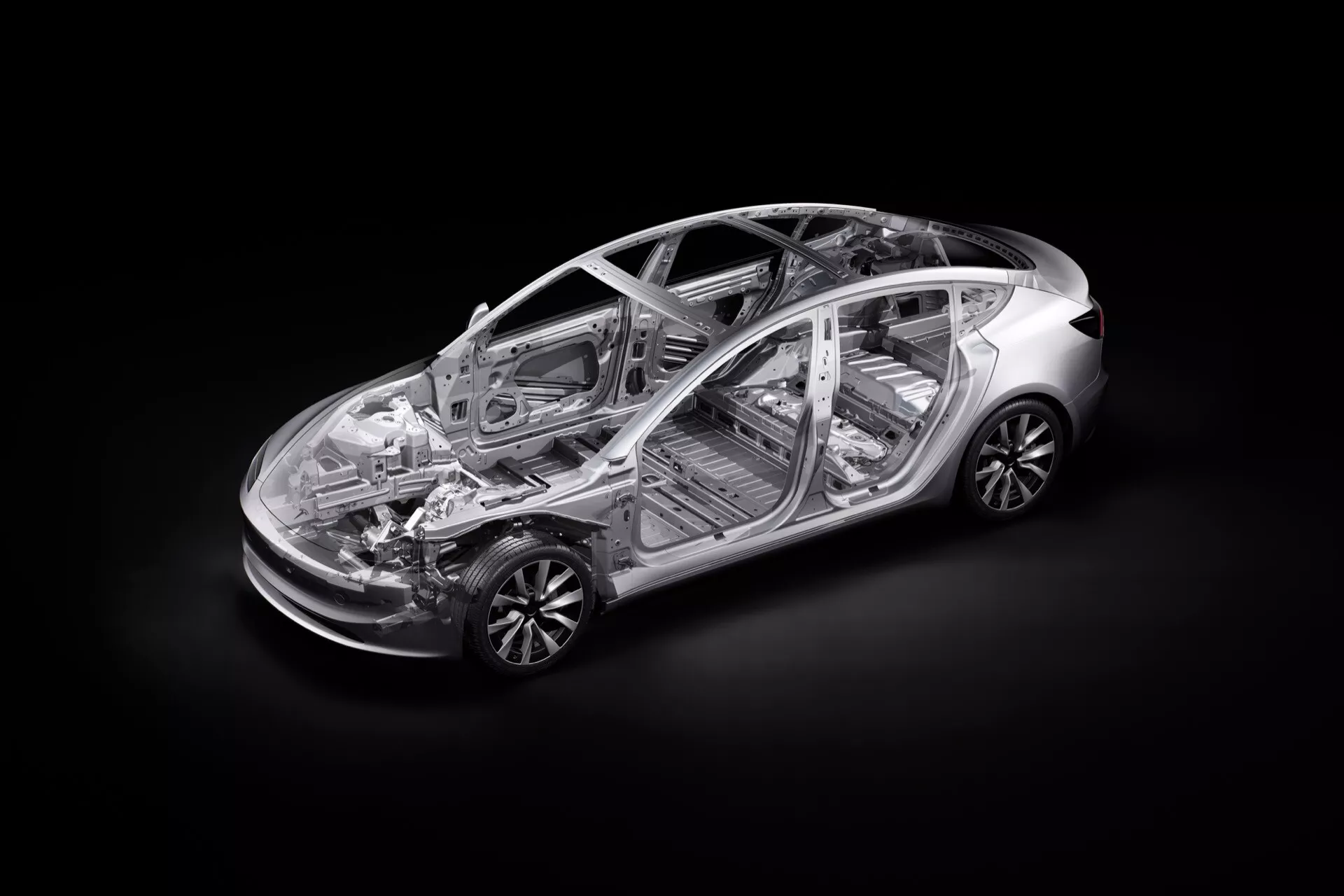 Vue transparente en plongée de la Tesla Model 3 2023 (facelift de première génération) montrant la structure interne et les composants, y compris le châssis, la cabine passagers et une partie du groupe motopropulseur, avec des vues détaillées des systèmes de suspension avant et arrière, des jantes en alliage et une allusion à la technologie de propulsion électrique.