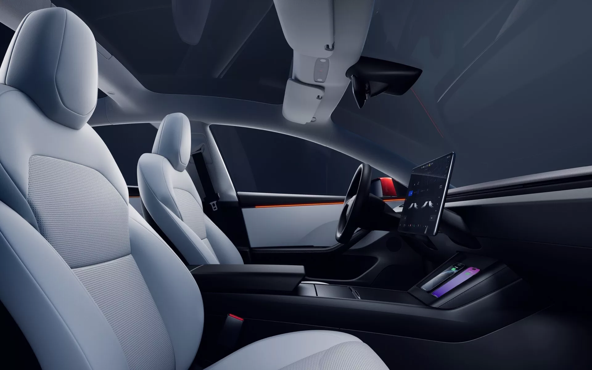 Vue intérieure de la Tesla Model 3 (1ère Génération Facelift) 2023 depuis le côté passager, montrant un cockpit avant moderne et minimaliste avec des sièges en cuir ou simili-cuir, un large écran sur le tableau de bord, un volant minimaliste à deux branches avec des commandes intégrées et une console centrale élégante