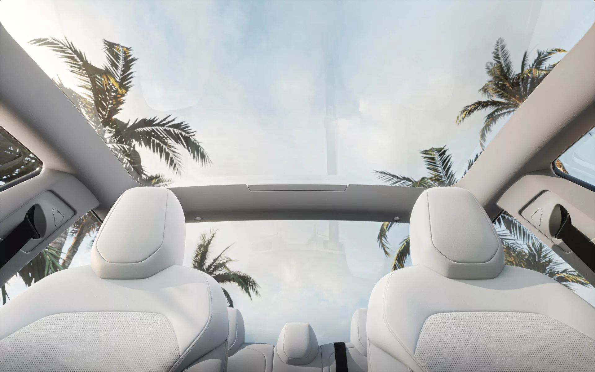 Vue intérieure de la Tesla Model 3 2023 (1ère Génération - Facelift) présentant le toit ouvrant panoramique avec vue sur le ciel, les nuages blancs et les palmiers, soulignant les sièges de luxe et la conception spacieuse de l'habitacle