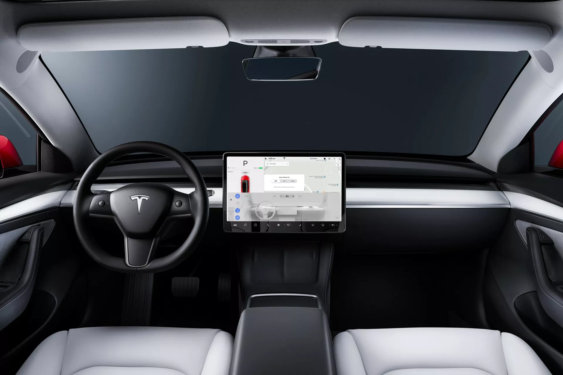 Vue intérieure d'une Tesla Model 3 de 2019 première génération depuis la perspective du siège arrière, présentant un tableau de bord minimaliste avec un grand écran tactile monté au centre. Le volant à deux branches avec un emblème Tesla, le thème bicolore avec des sièges blancs et des accents noirs, le design moderne des sièges, les bouches d'aération fines et l'absence de jauges visibles indiquent une intégration technologique sophistiquée et le design d'un véhicule électrique.